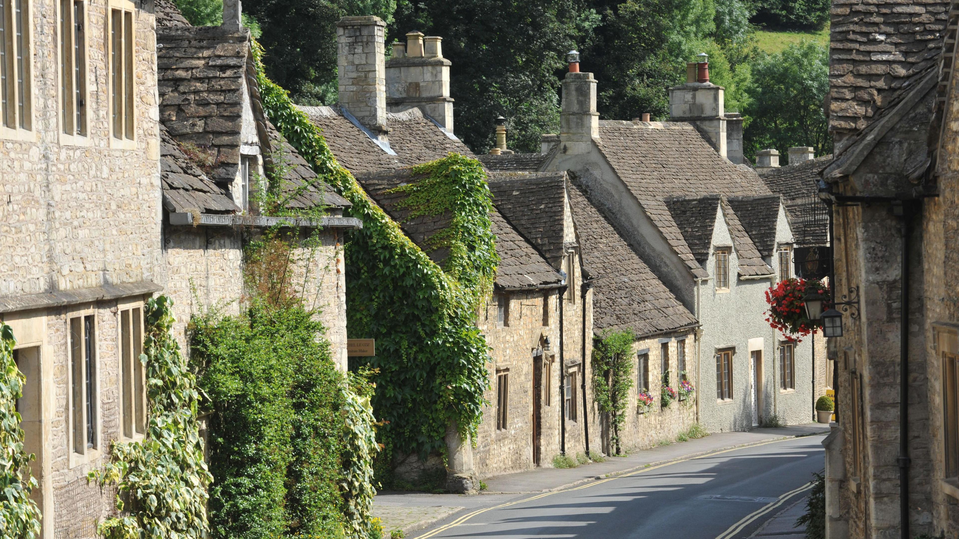 A narrow road with quaint Cotswold stone cottages on both sides