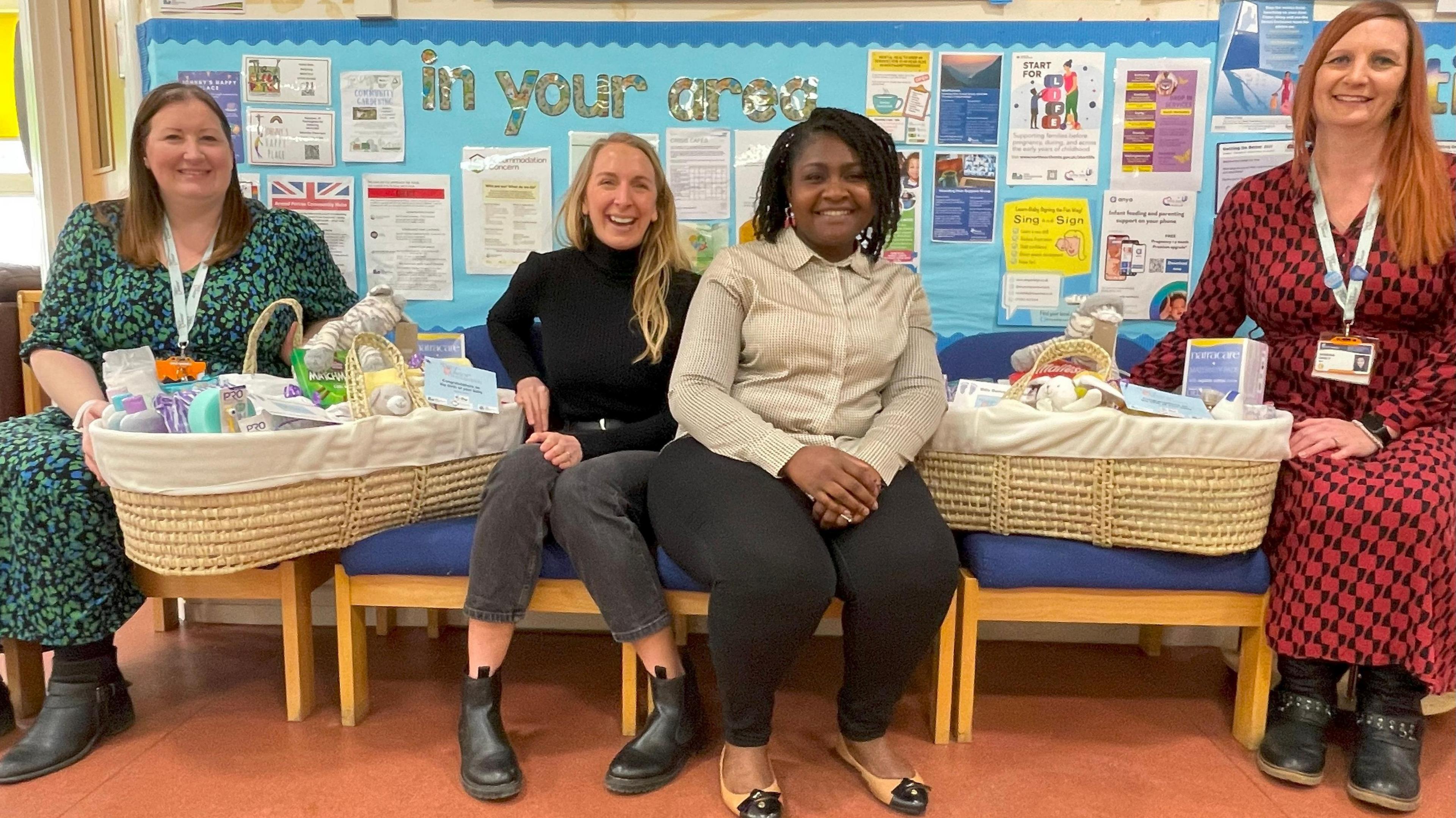 Four volunteers sitting with baskets full of supplies