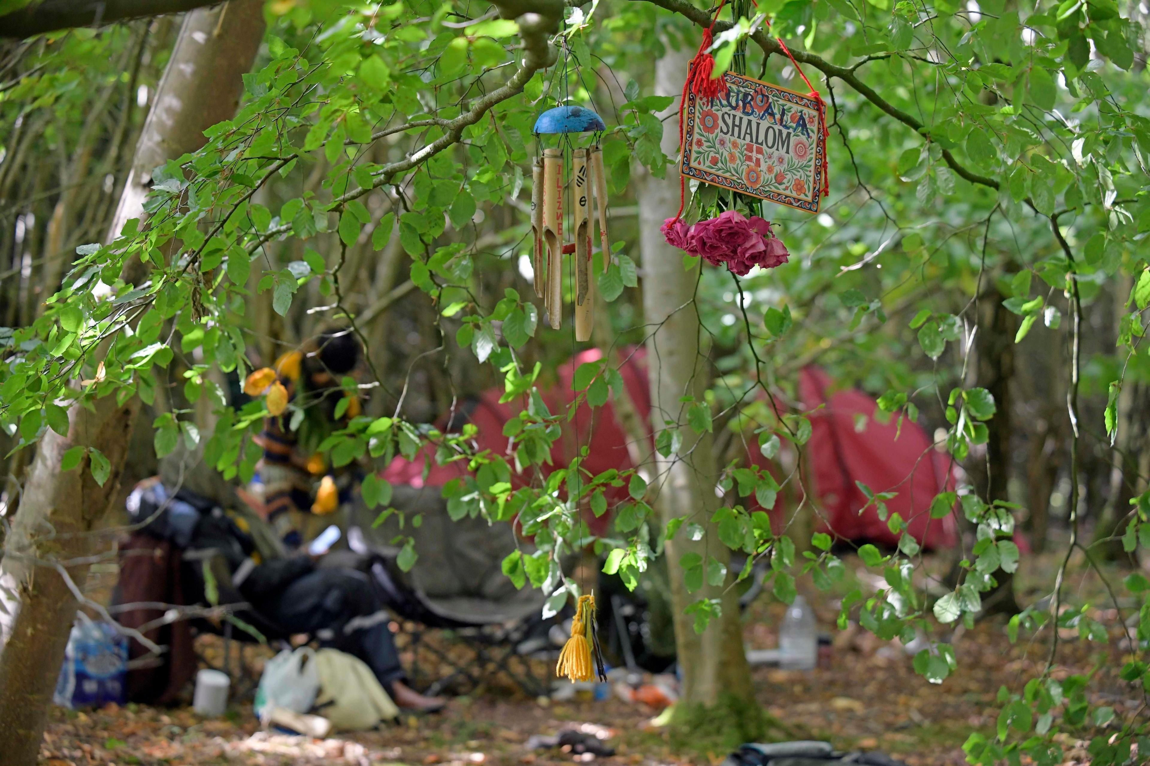 A camp site in the Borders with chairs, a tent and some wind chimes hanging from a tree