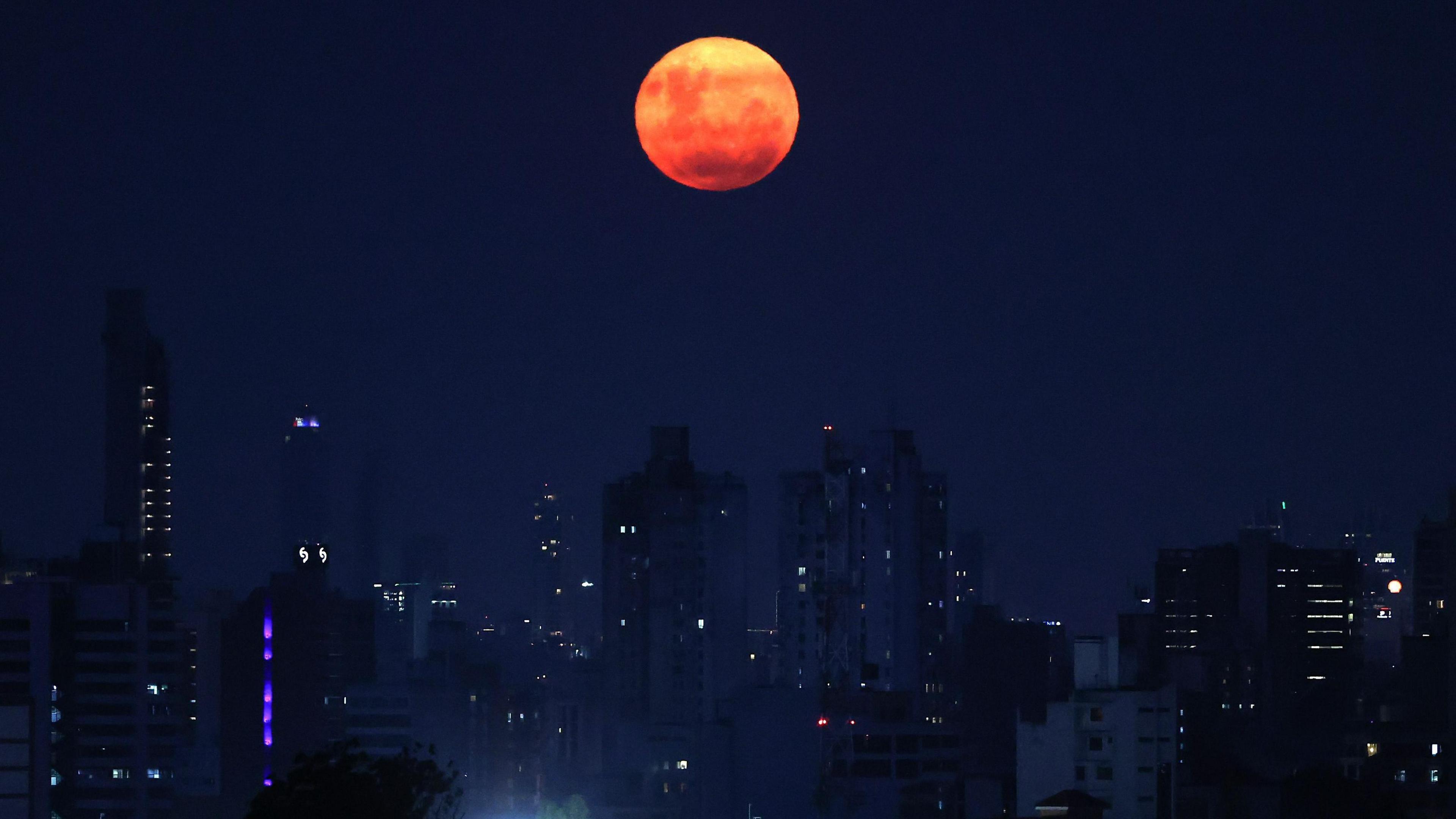 A red moon over a city skyline