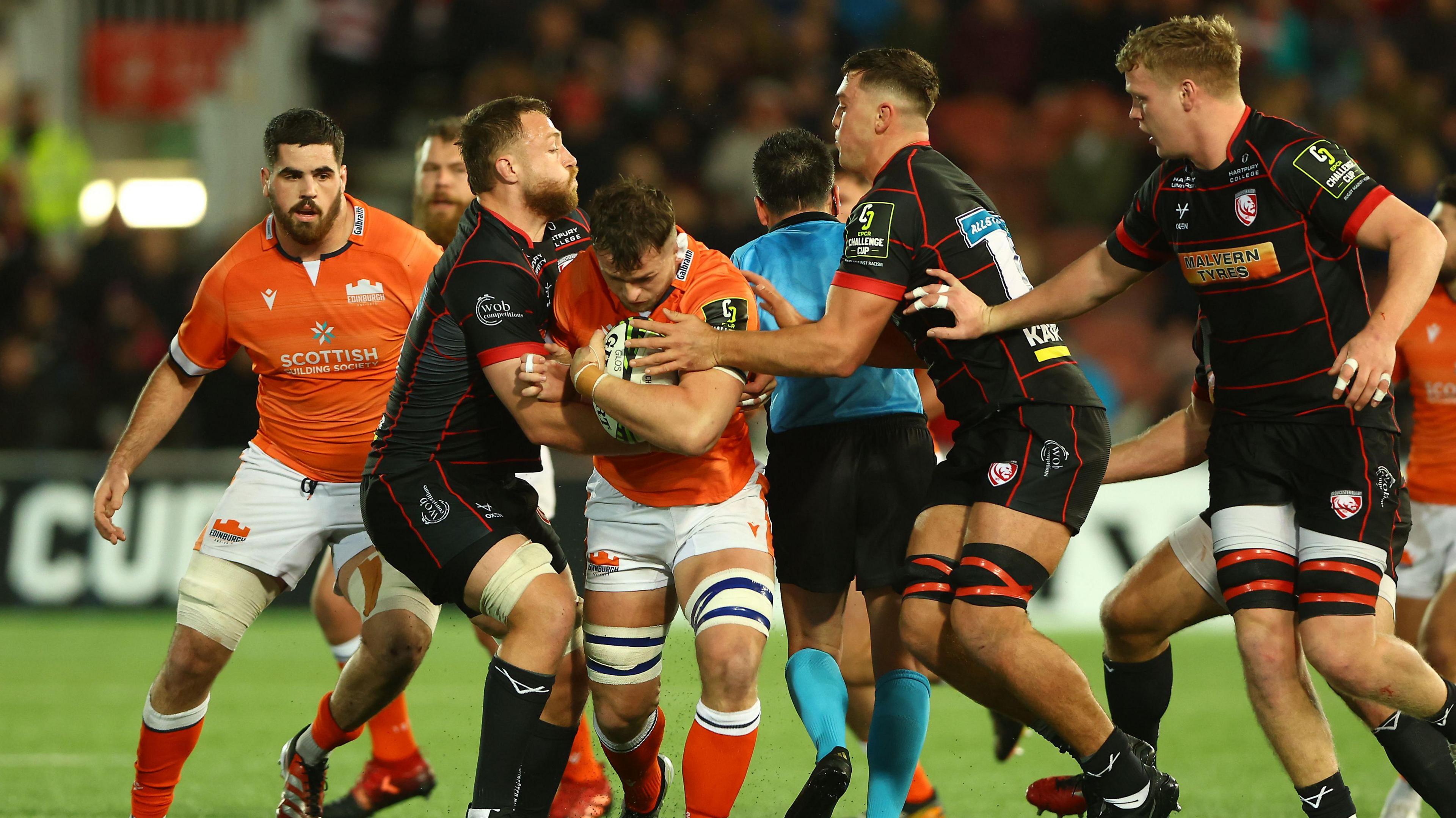 Magnus Bradbury runs into a tackle from two Gloucester players