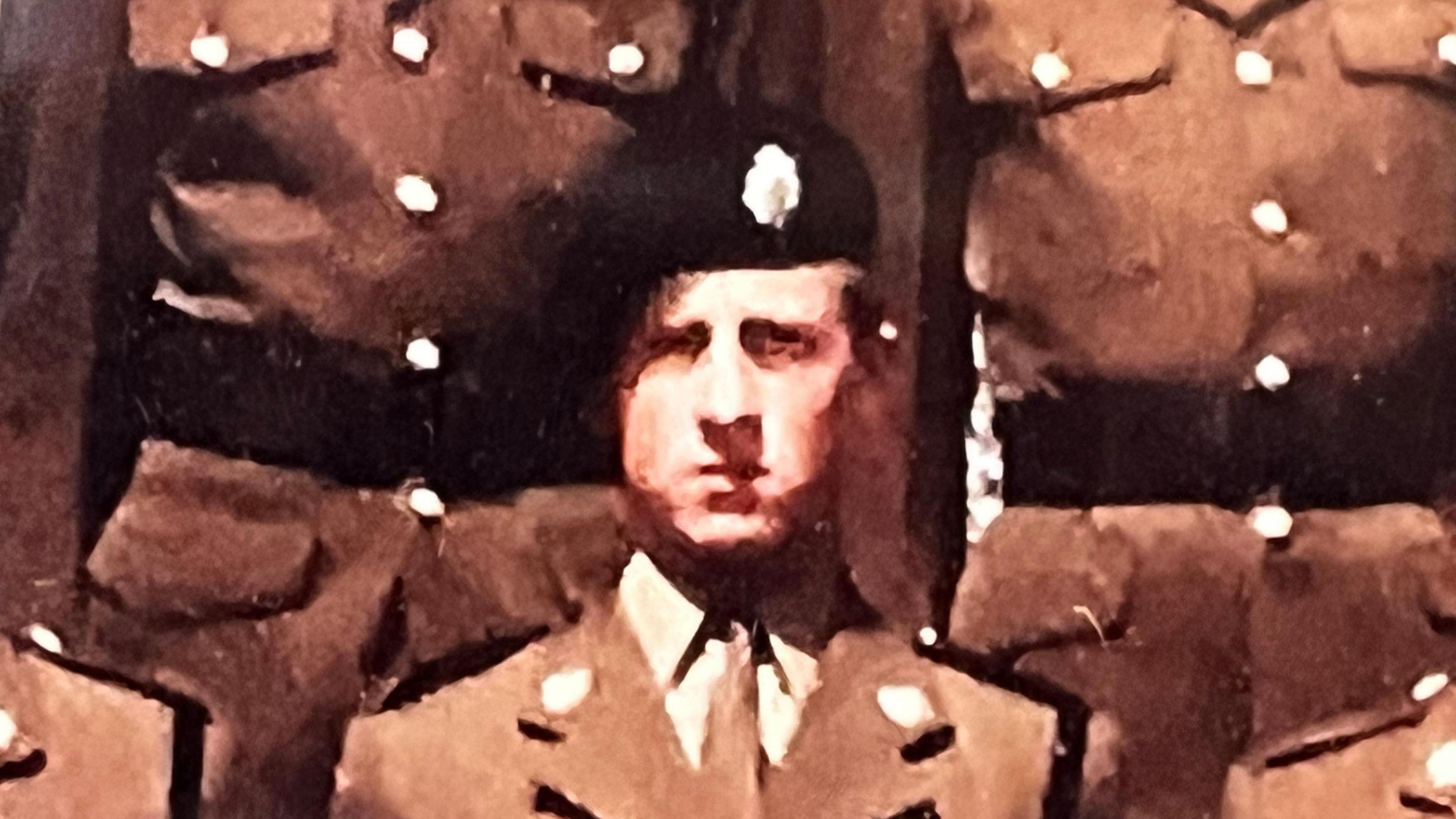 A slightly grainy photograph of a young man wearing a brown army uniform and a black beret with a silver badge on it. It's a formal photo, and Mr Tolhurst is standing shoulder to shoulder with other soldiers, but their faces are cropped out.