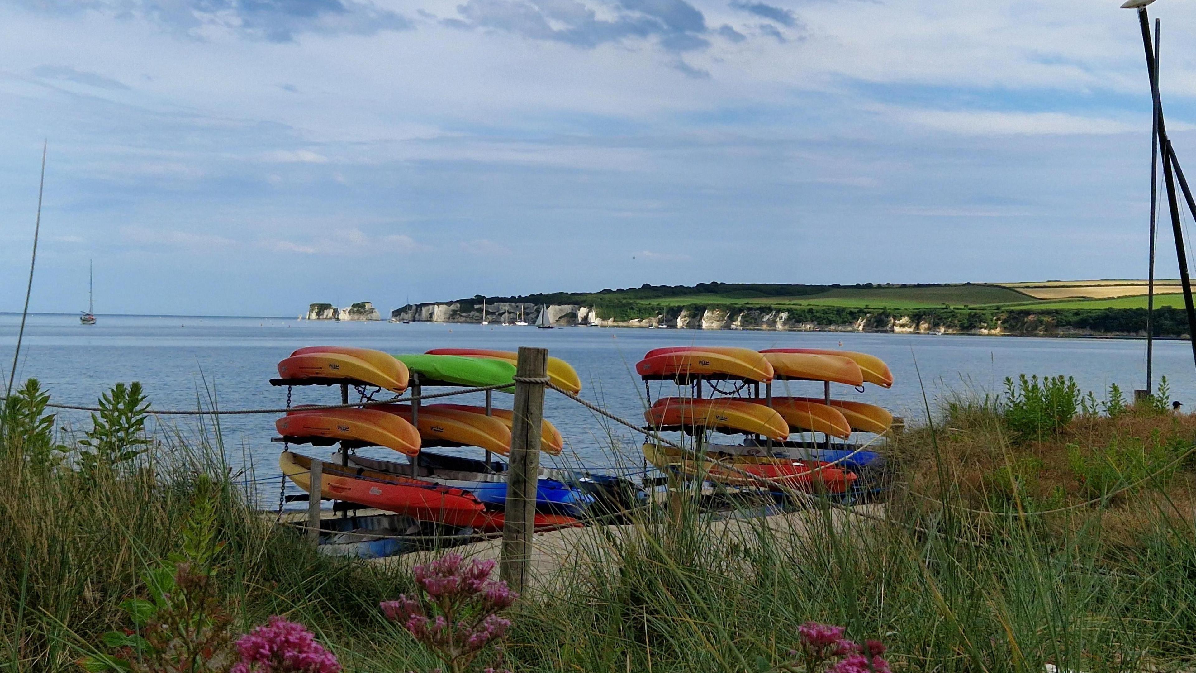 SATURDAY - Kayaks on the beach at Studland with Old Harry Rocks in the background