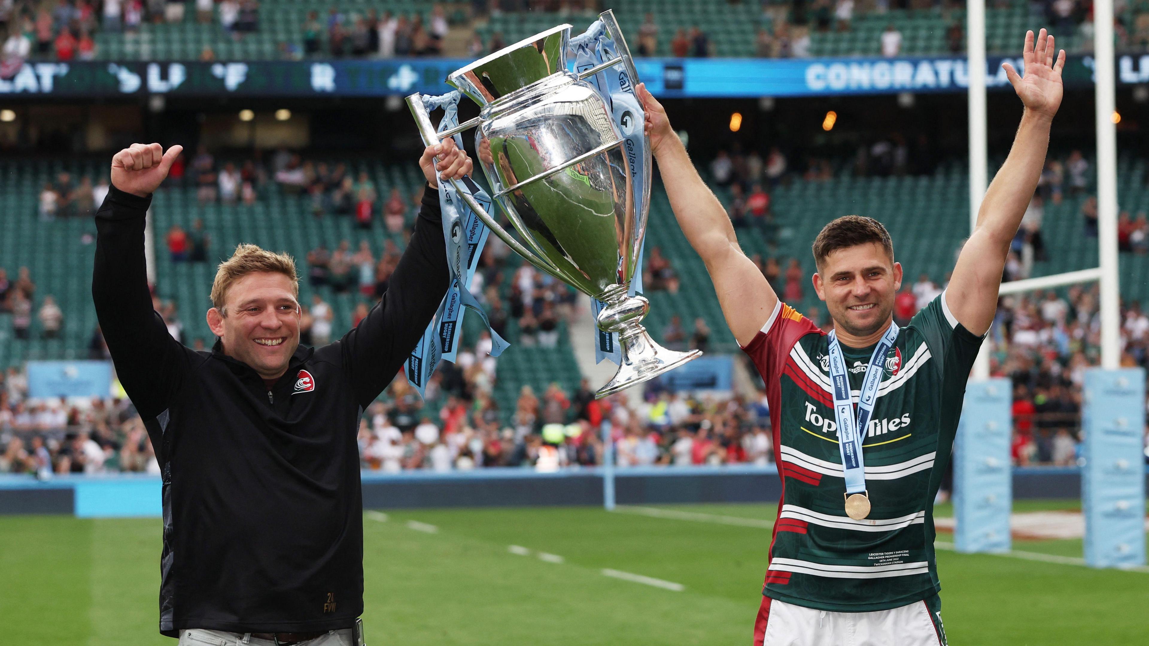 Tom Youngs and Ben Youngs holding a trophy together. 
