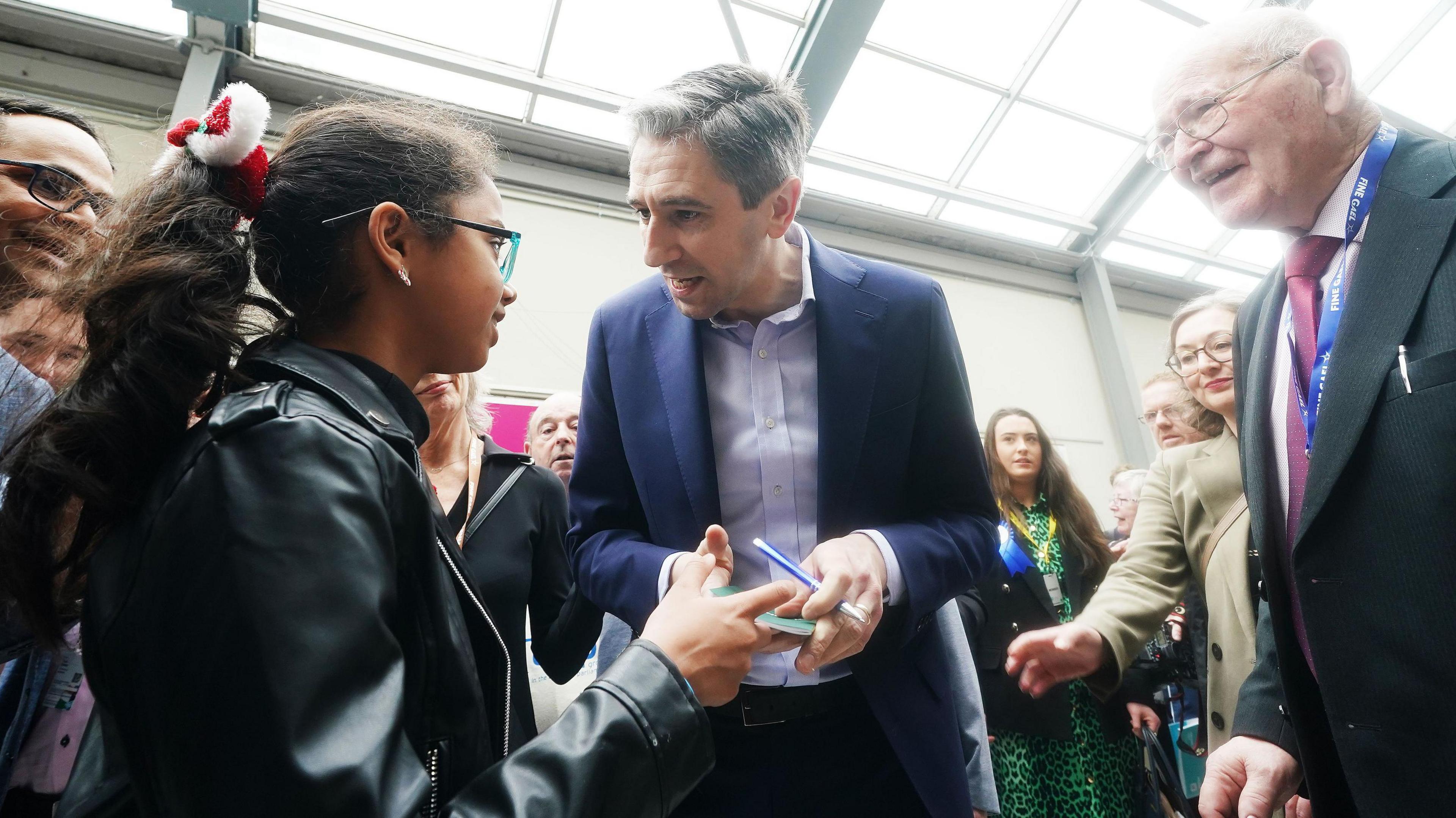 Simon Harris speaks to a young girl at the Fine Gael conference