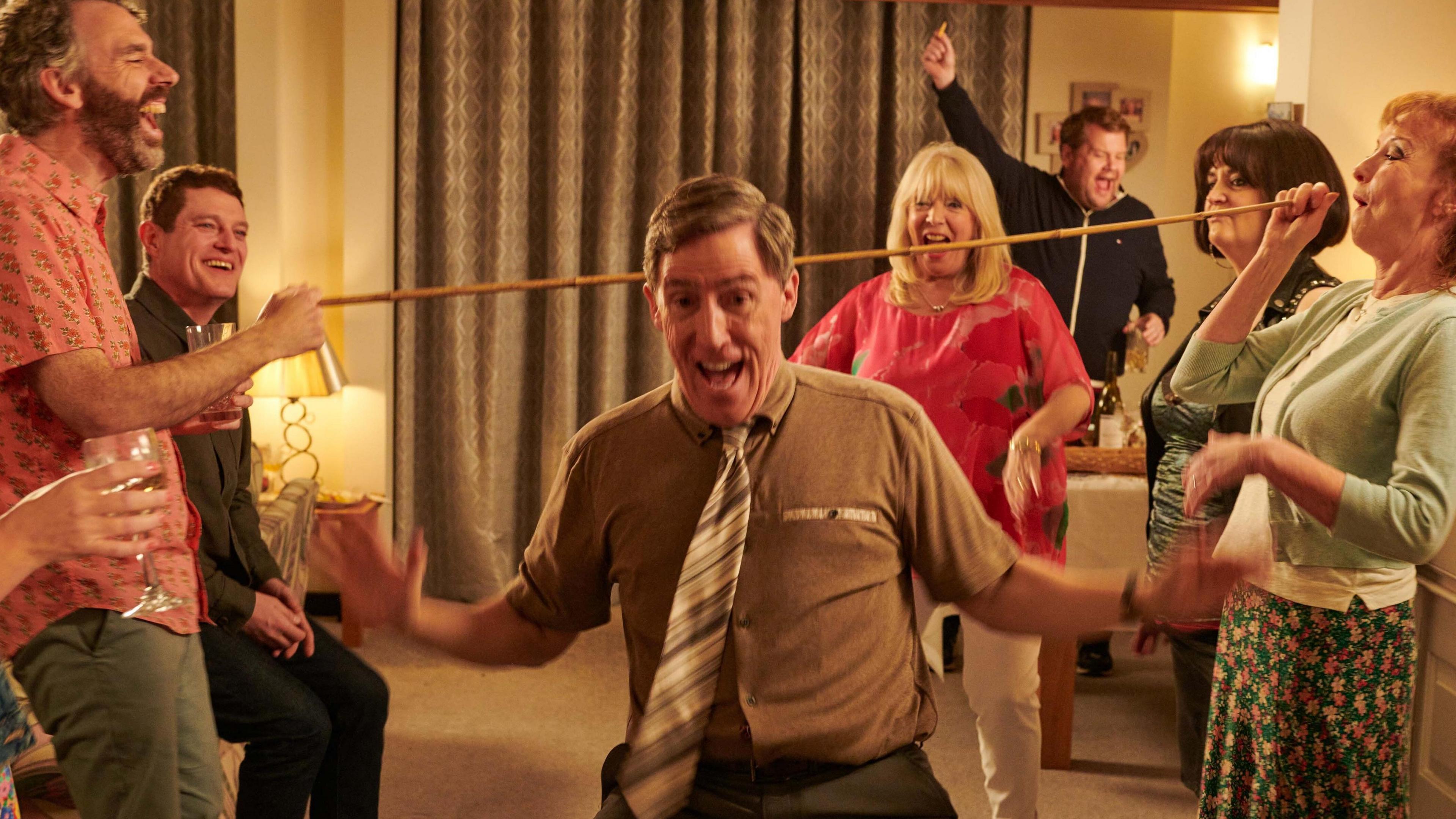 Rob Brydon pictured doing the limbo on set at Pam & Mick's house in Essex.