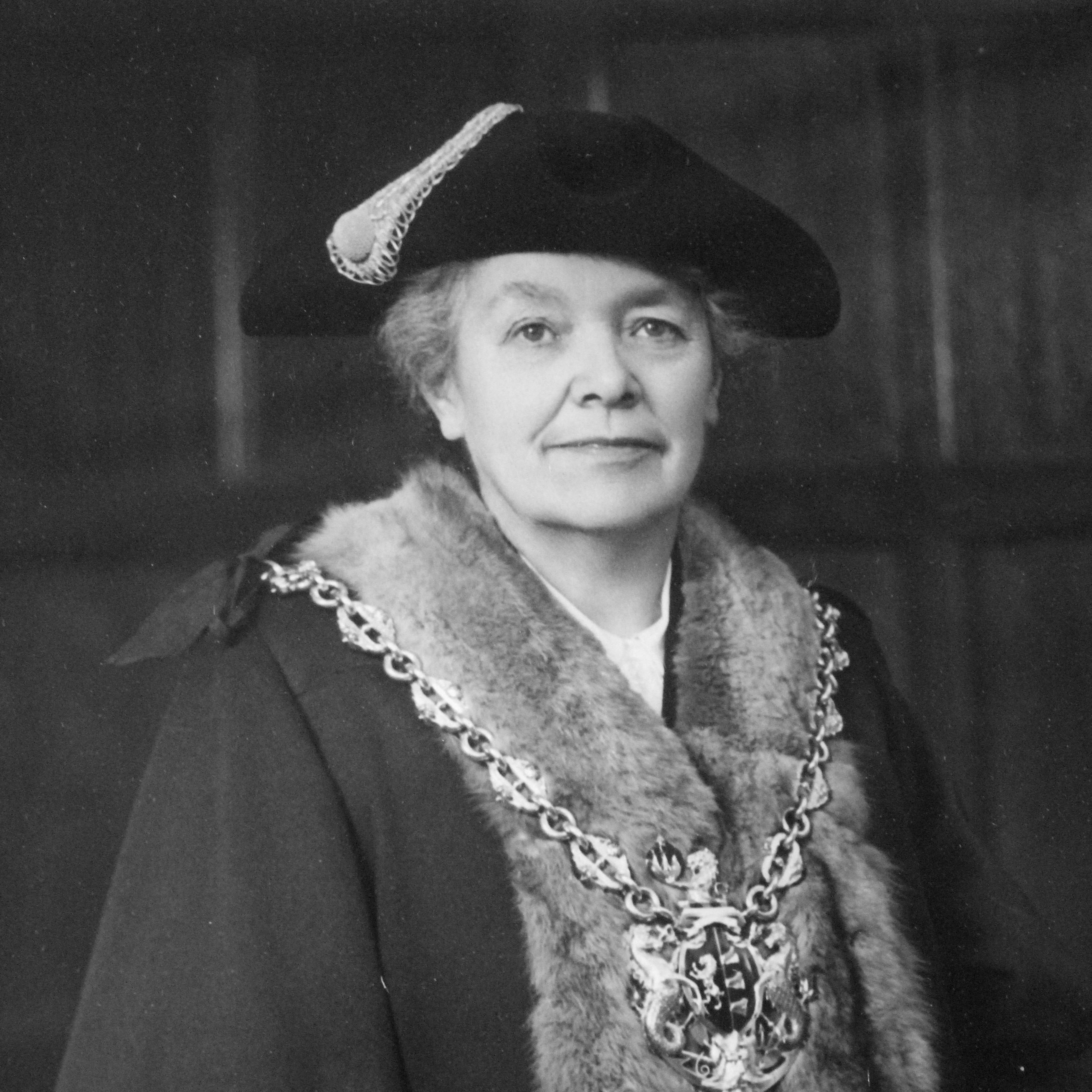 A woman with a fur trim to formal mayoral gown and ceremonial chain