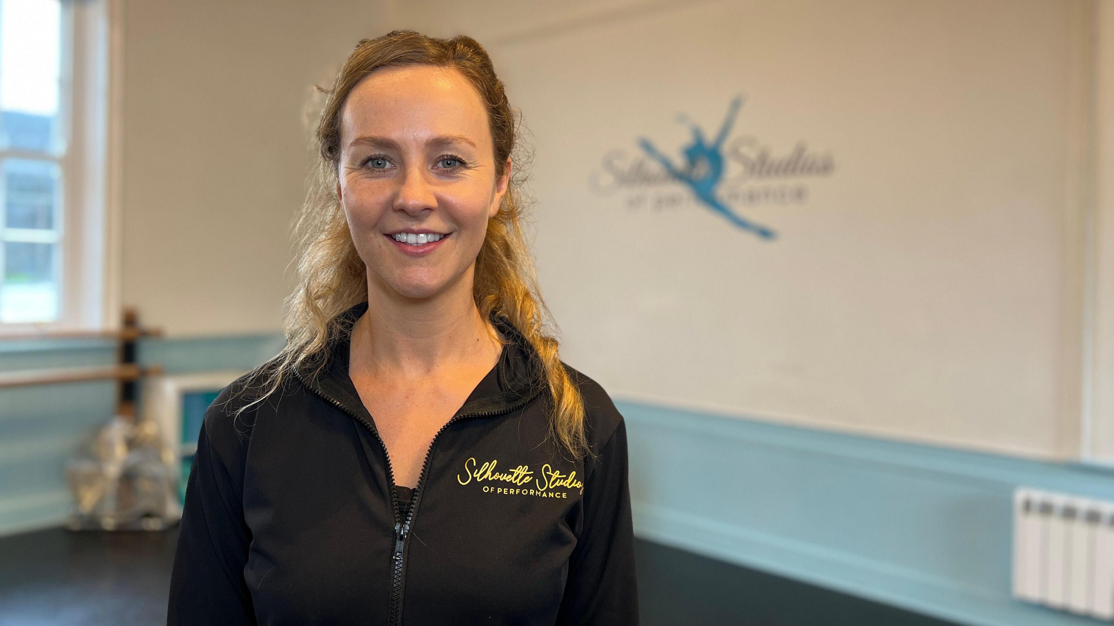 Narelle smiles at the camera in her dance studio