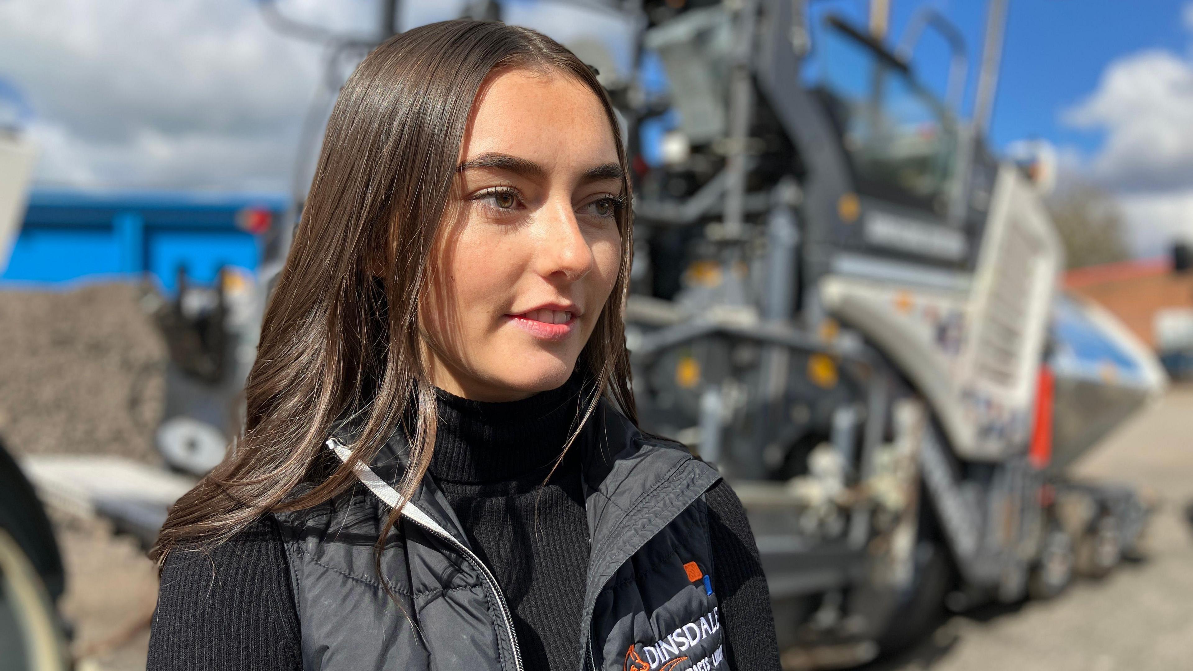 Georgia Coleman standing in front of one of the company's resurfacing machines