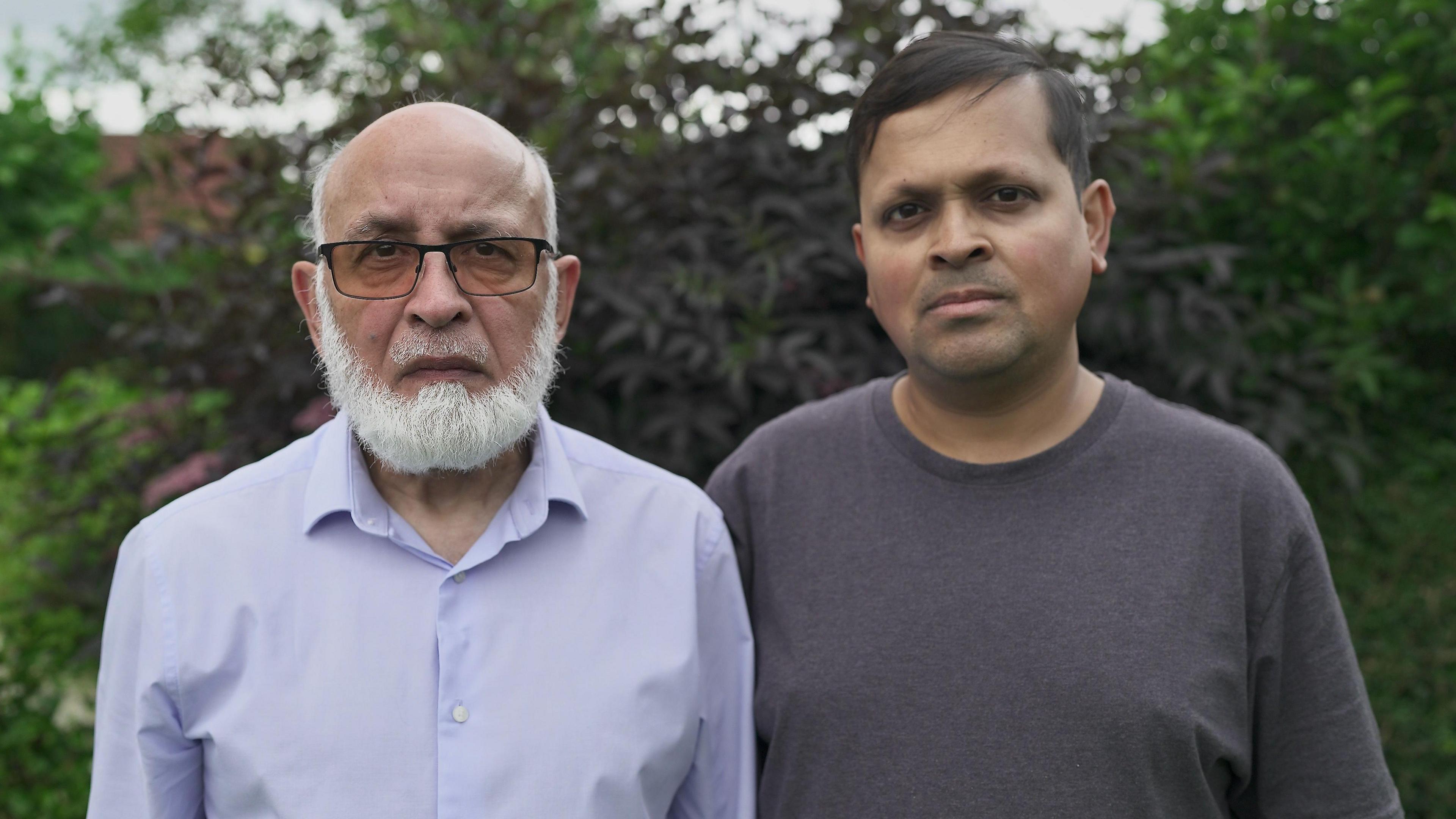 L-R: Mohammad Rasul and his son, Yameen, looking sombre and staring into the camera