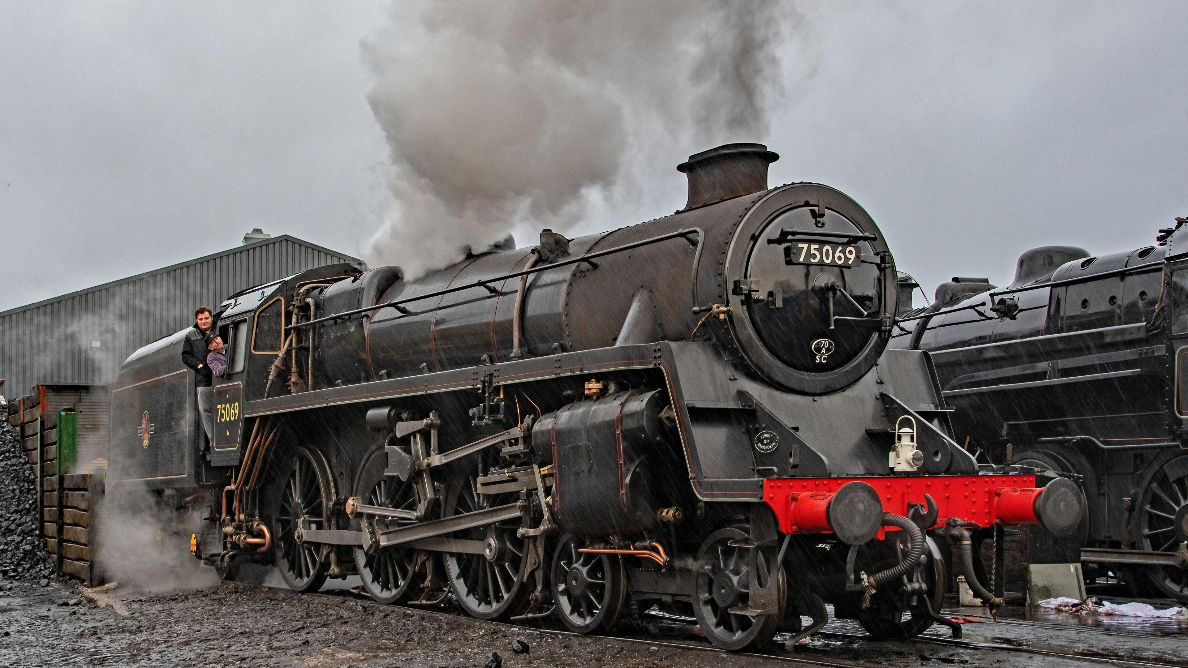 Driver Mick Matthews whistles up, sitting inside the carriage, with fireman Alex Robinson standing beside him, as the black and red 75069 train is prepared for events in December.