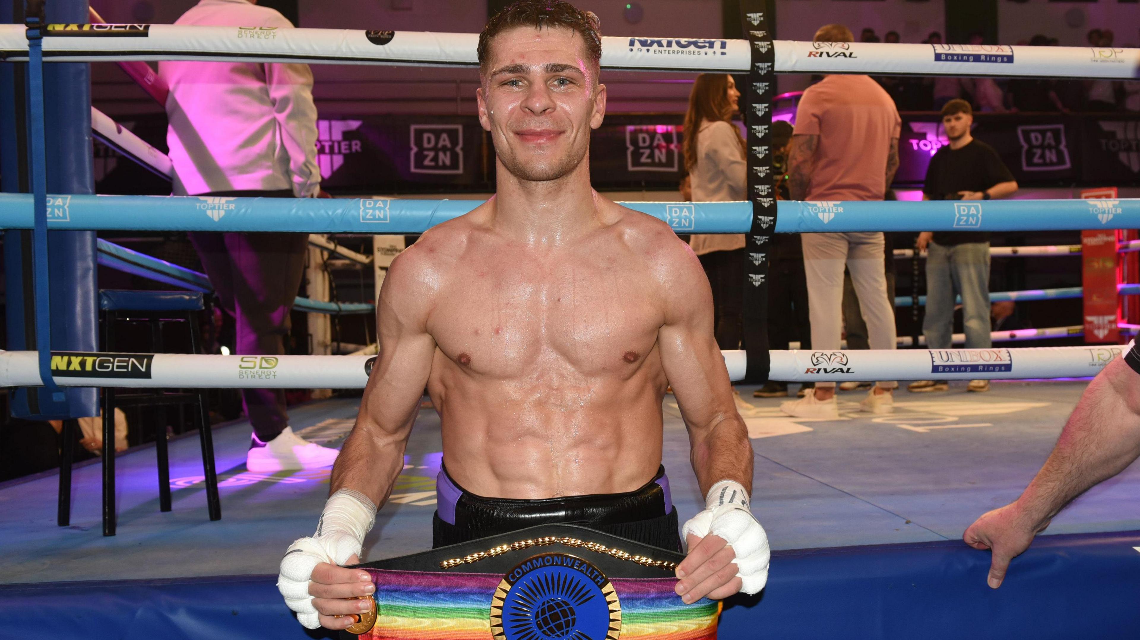 Constantin Ursu smiling while holding a boxing belt in his hands