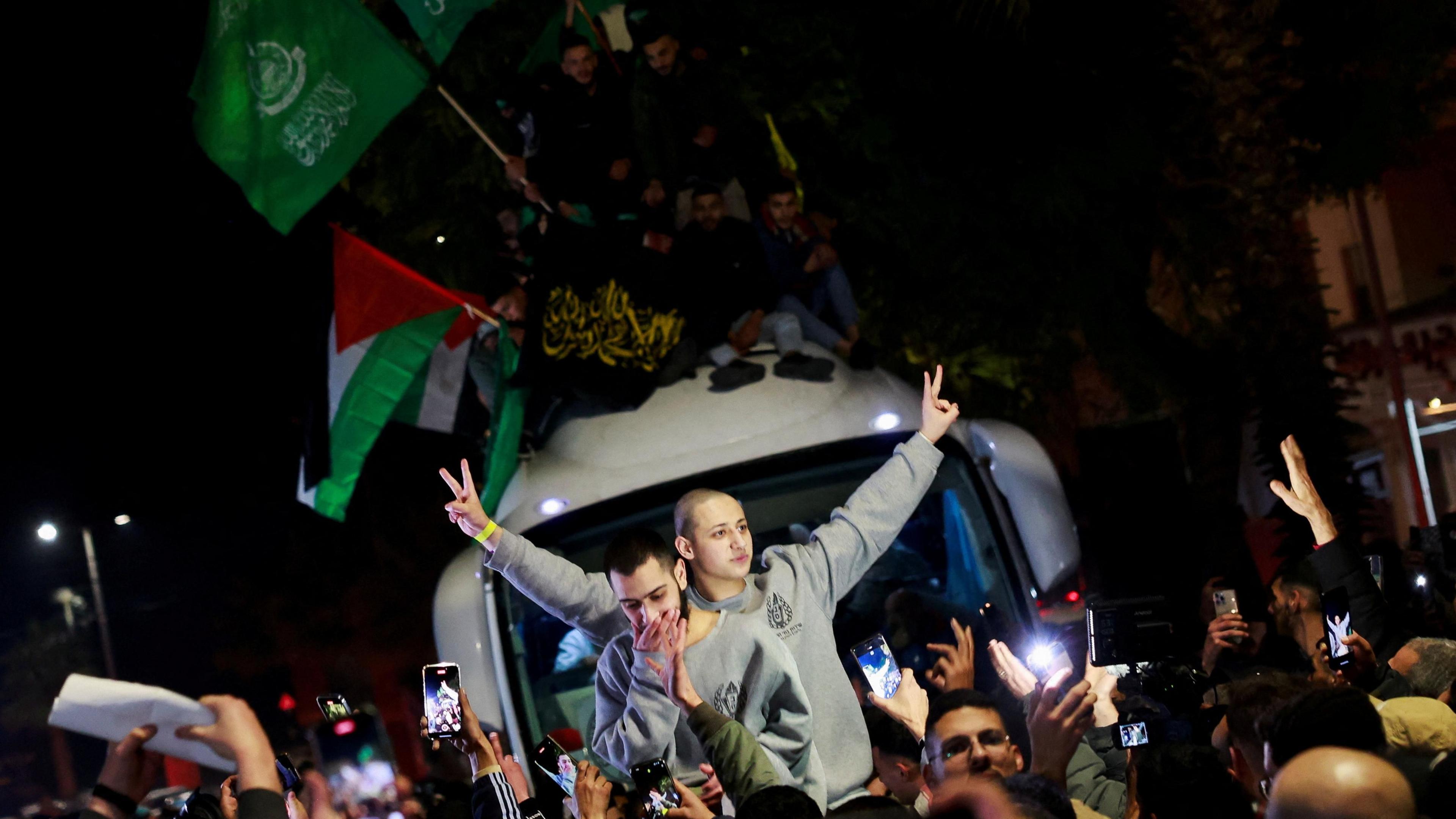 Palestinians gesture after being freed from Israeli jails as part of a Gaza ceasefire and hostage release deal, in the occupied West Bank (20 January 2025)