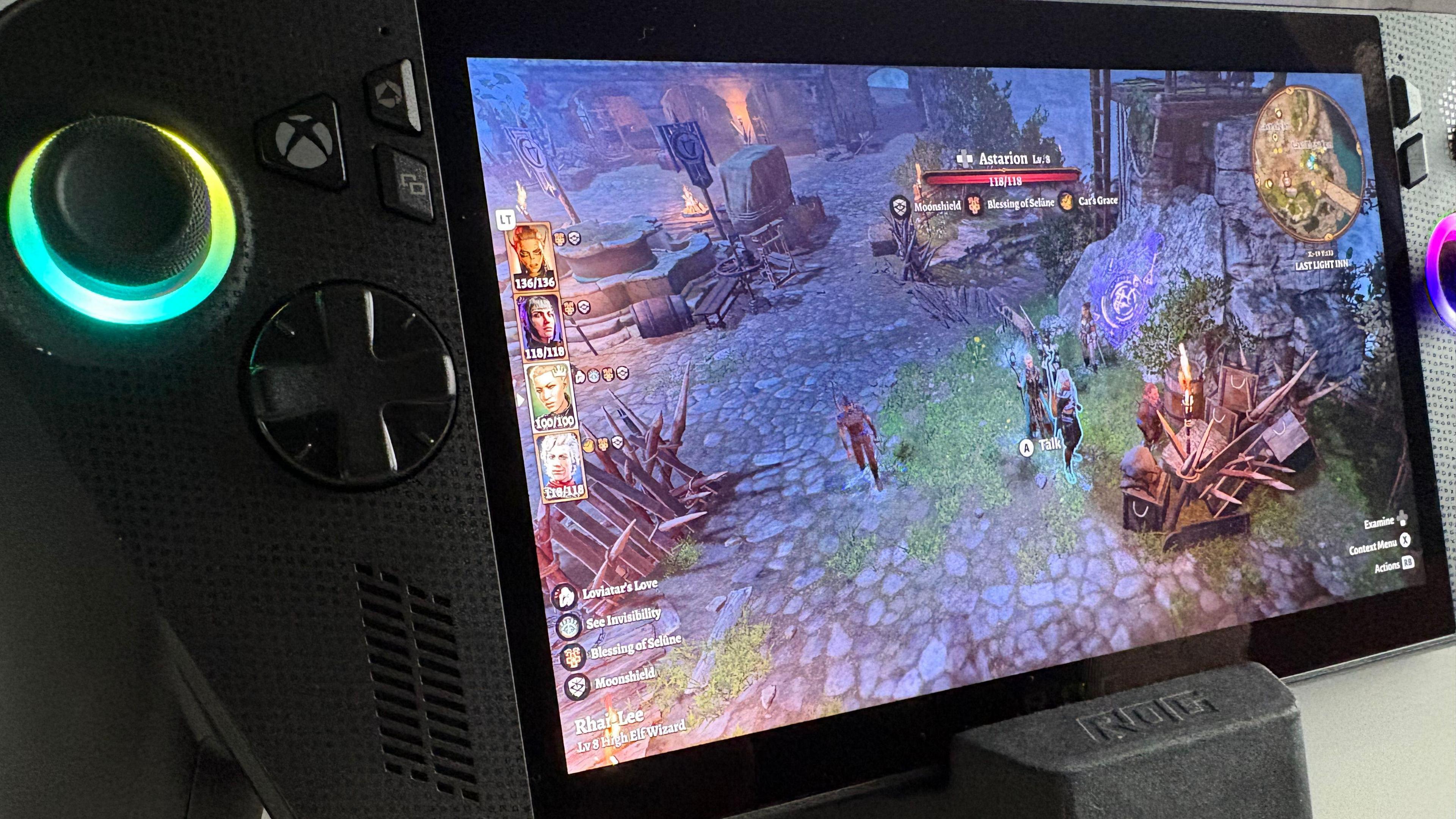 The Xbox handheld against a white background on a stand. On the screen is Baldur's Gate 3. It is very busy. There are small characters in the middle that are hard to make out, their portraits on the left in small boxes, and lots of different text boxes on the screen. A health bar for a character called Astarion is at the top. On the right is a small mini-map. The colours are nice and vibrant.
