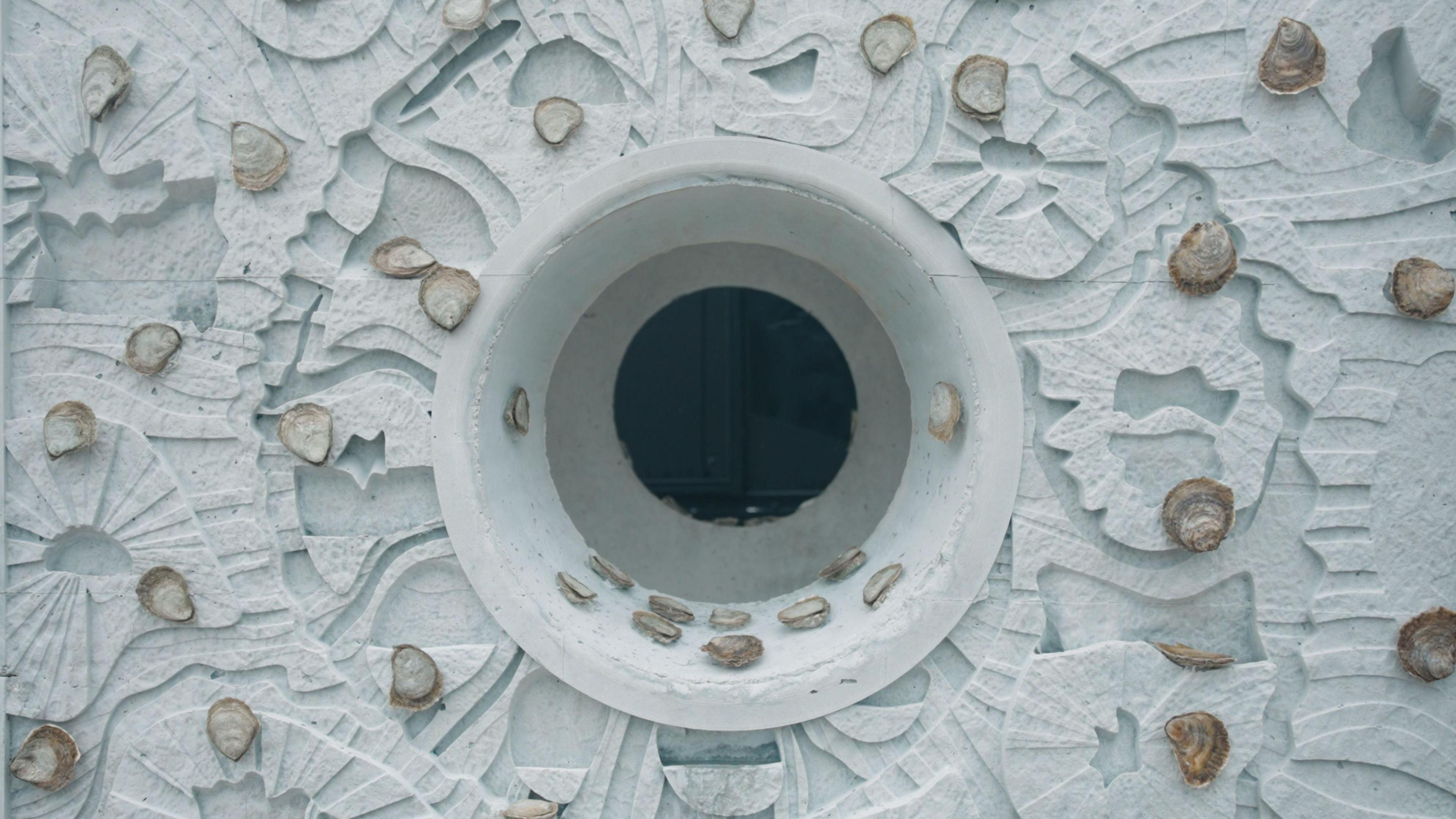 Native oysters attached to oyster reef cubes ahead of their deployment in the North Sea. The cube is square with a round hole at tit centre. It is engraved in various shapes mimicking the seabed. 