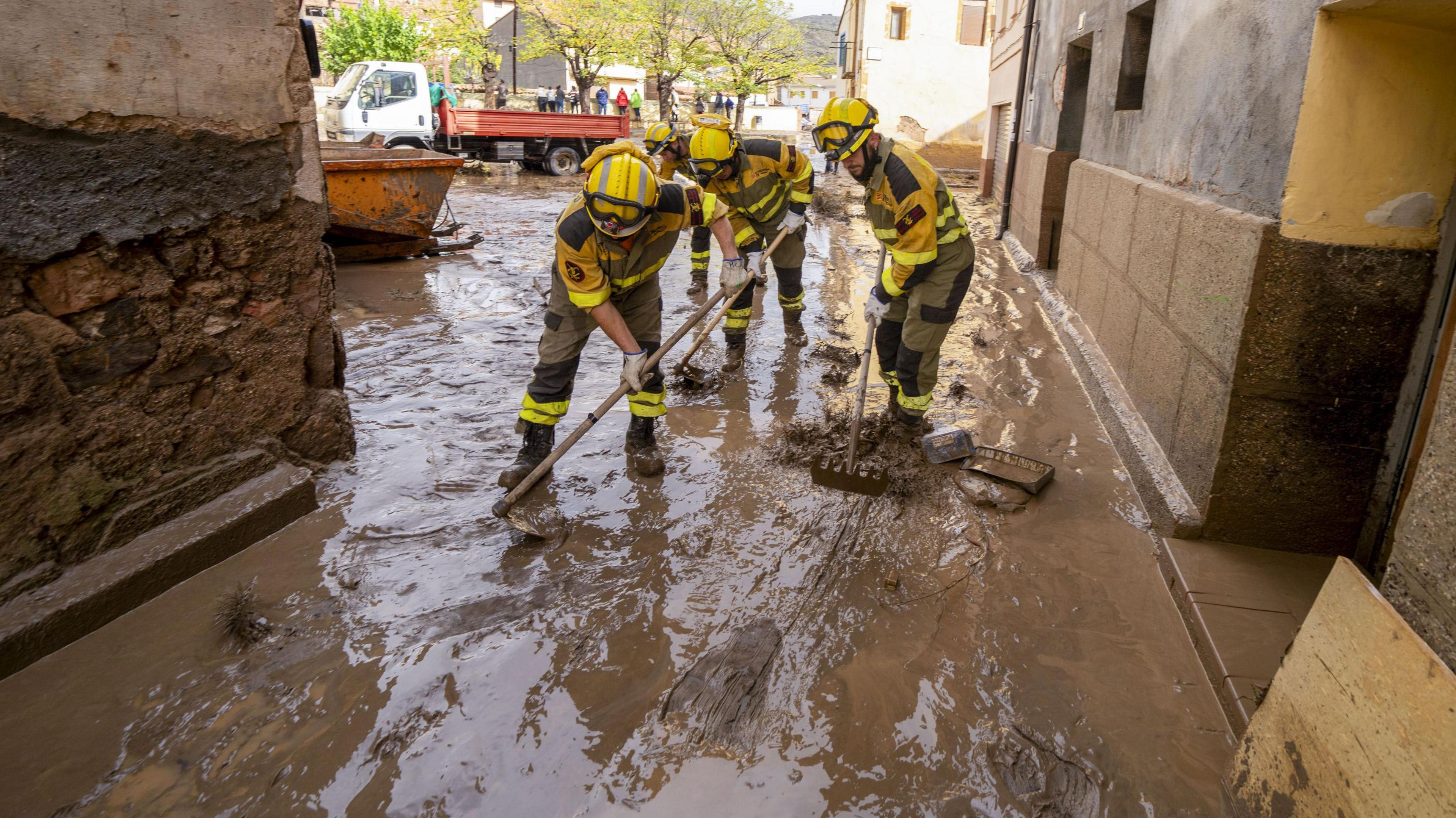 emergency service workers sweeping up flood waters