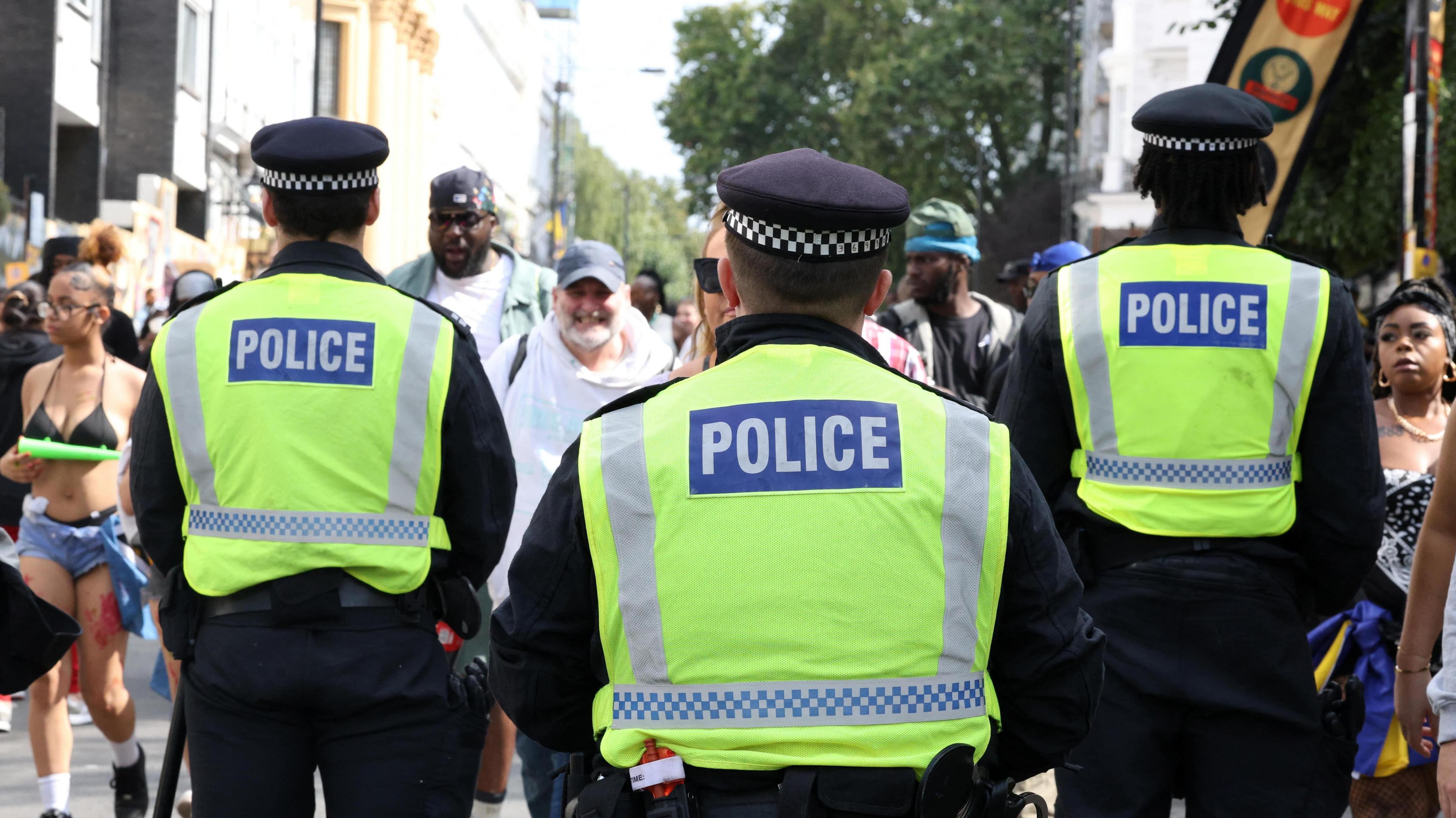 A general view of the back of three Metropolitan Police officers at Notting Hill Carnival.