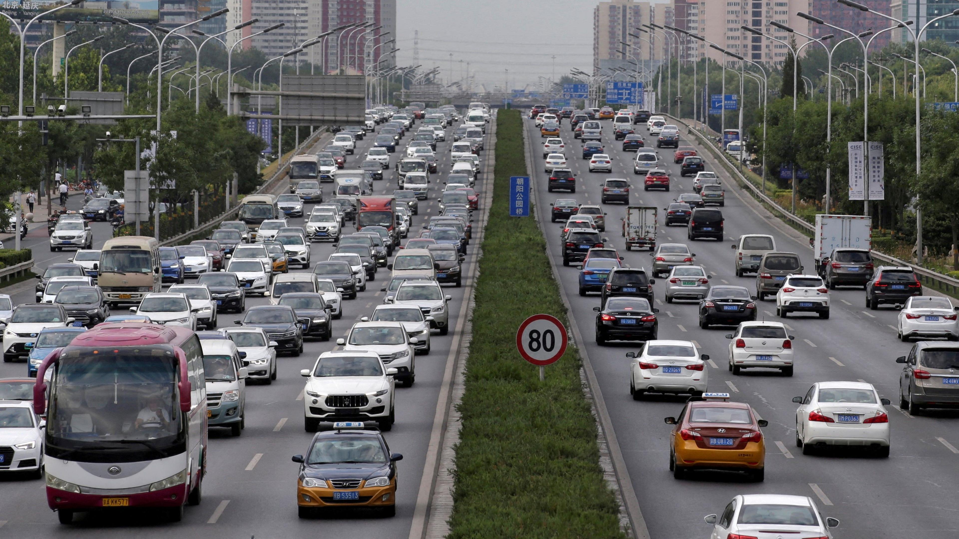 Cars drive on the road during the morning rush hour in Beijing