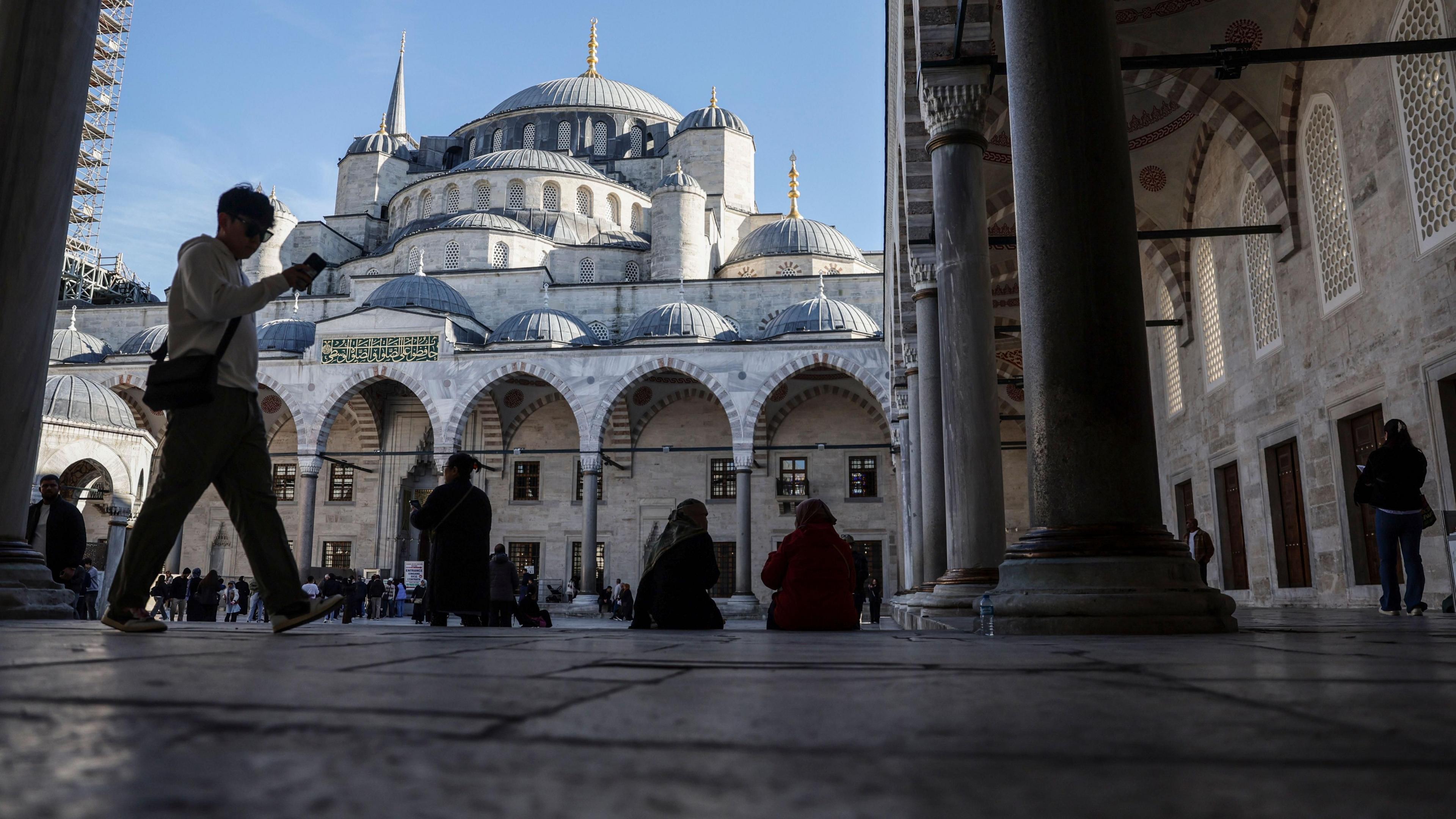 People rest in the shade in front of Istanbul's Blue Mosque.