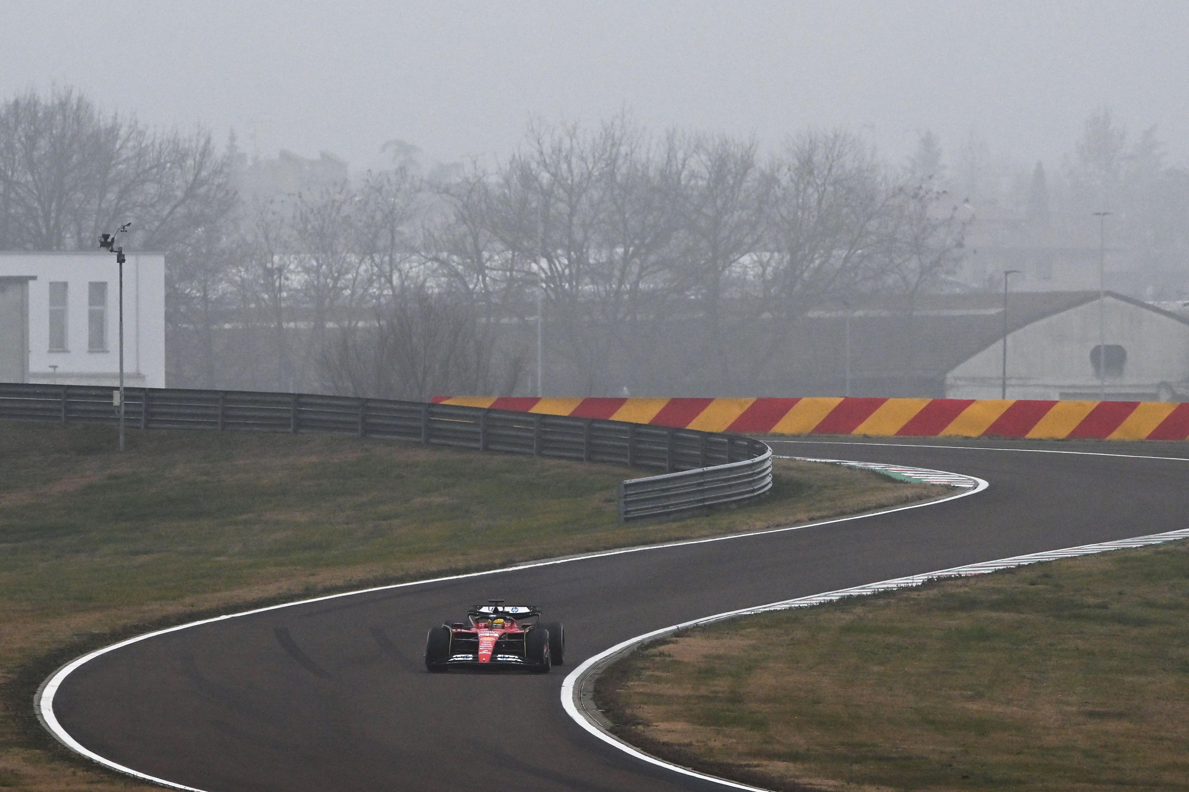 Lewis Hamilton is seen in a Ferrari against a foggy backdrop