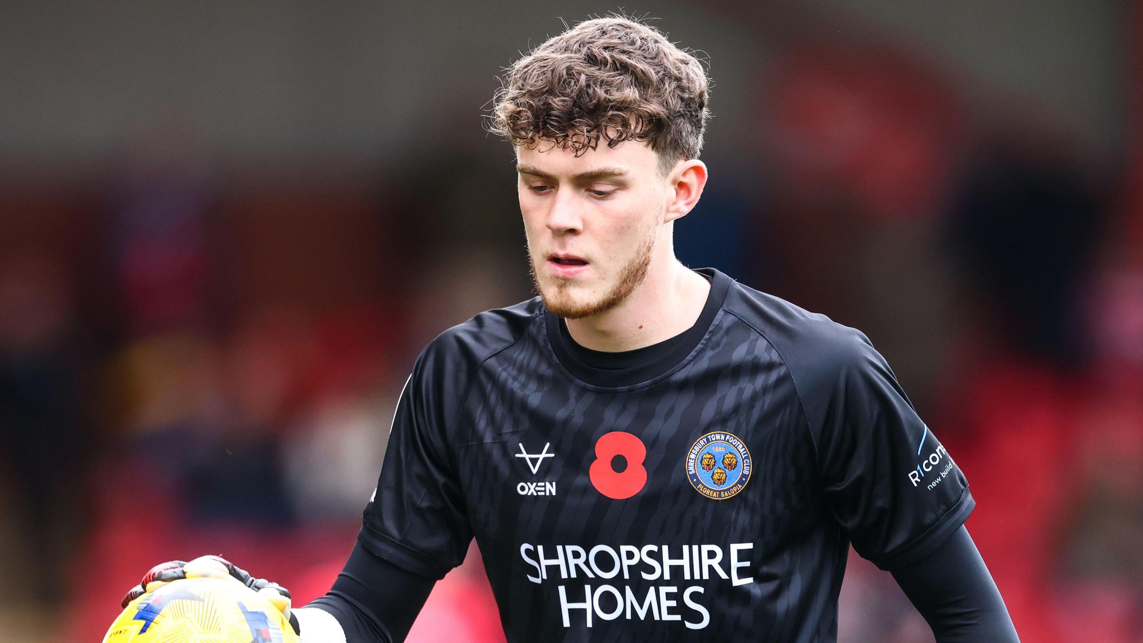 Will Brook looks down as he bounces the ball during a match