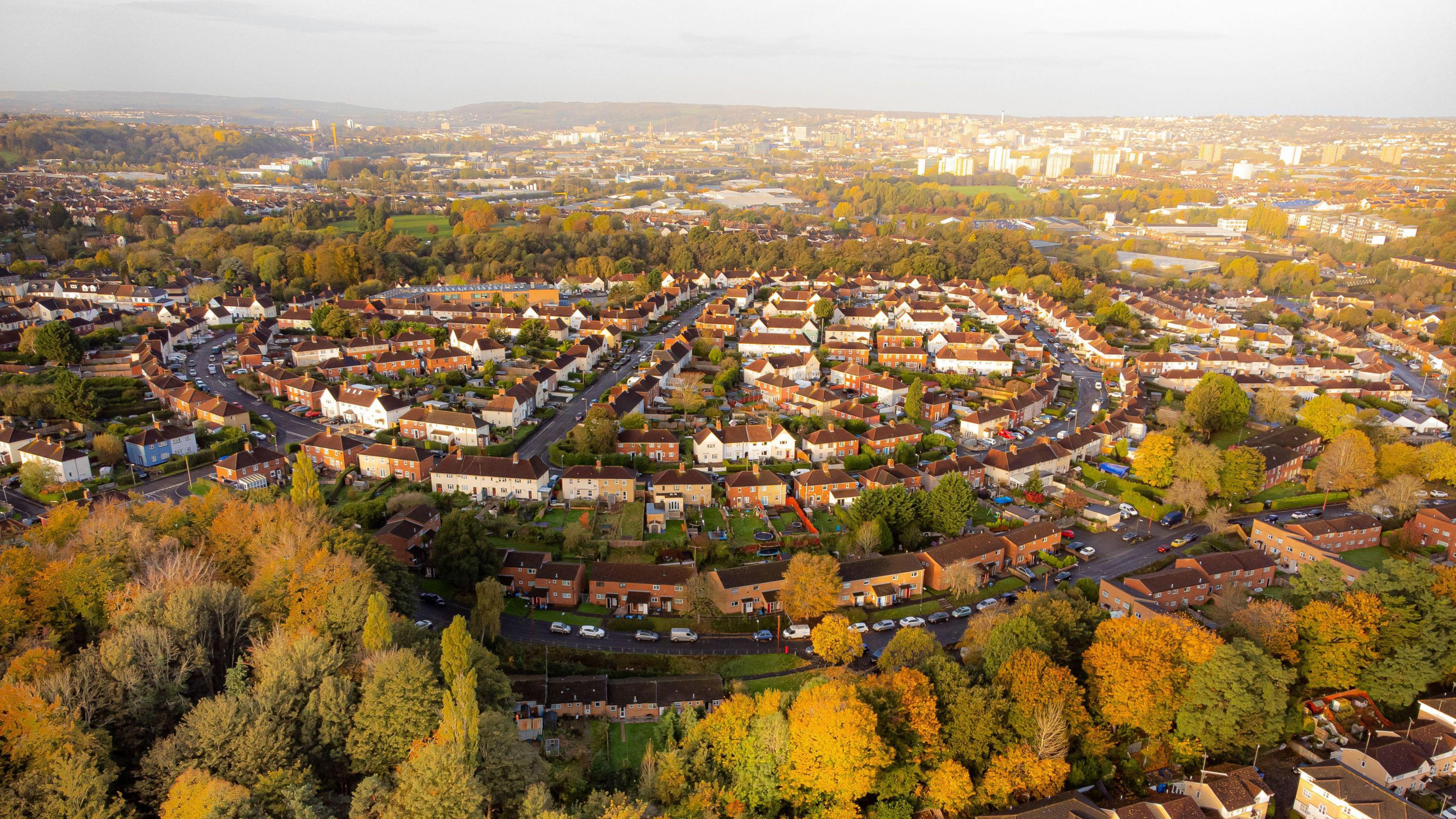 An aerial view of a housing estate in Bristol surrounded by trees with autumnal leaves