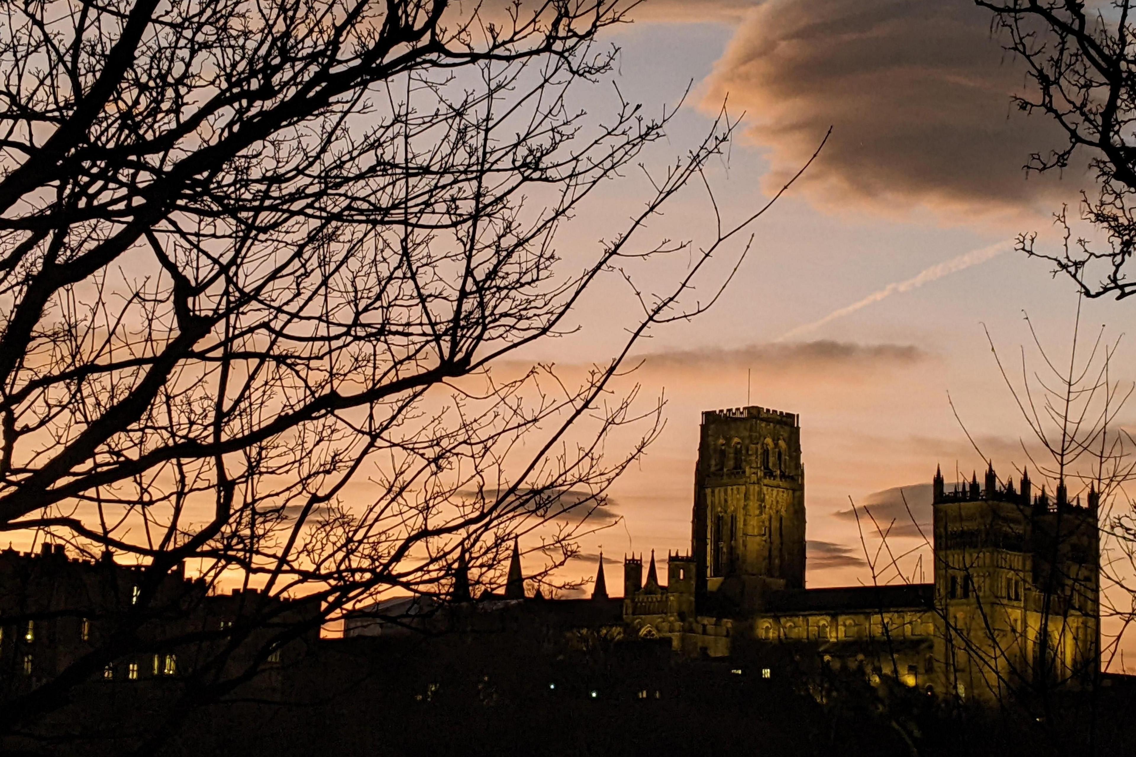 Durham Cathedral is lit at dusk.