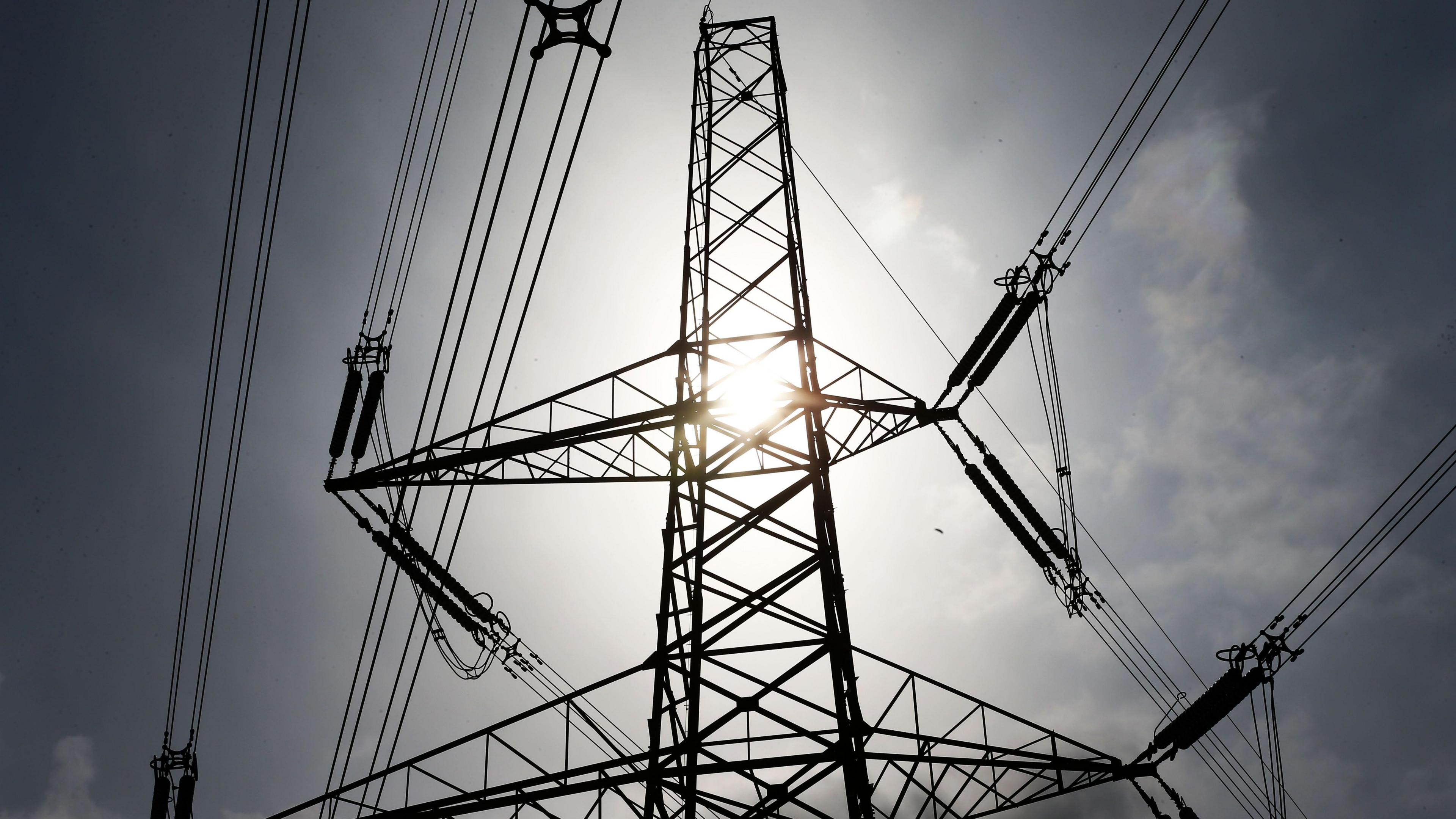 A pylon seen close up with the sun shining through the middle