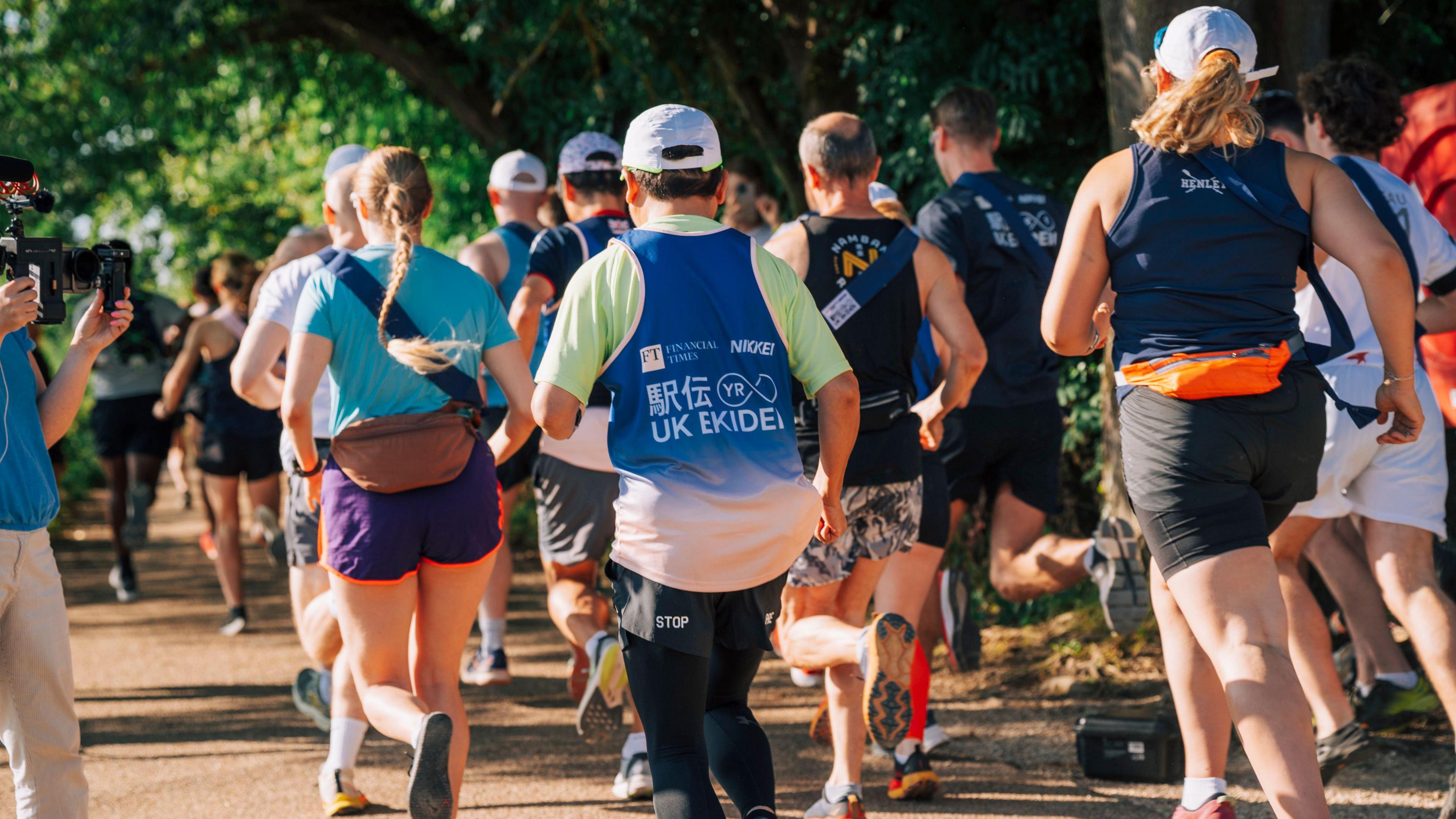 UK Ekiden runners setting off from Oxford on the Thames Path with journalists covering the event from the side lines