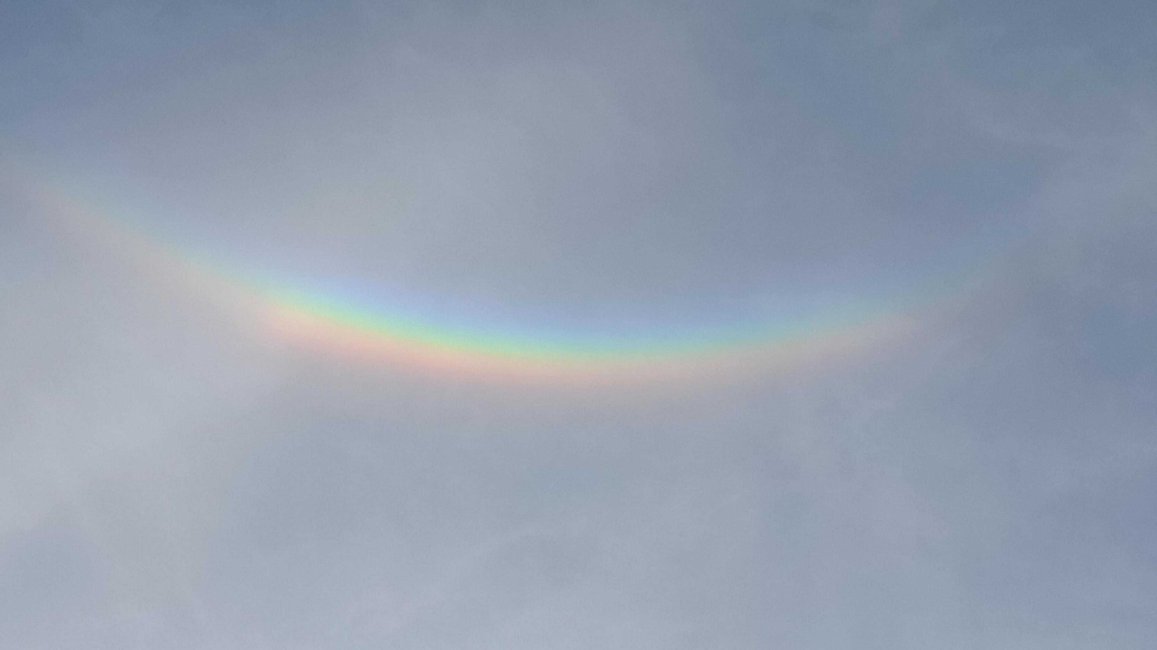 An upside down "rainbow" seen against a clear blue sky.