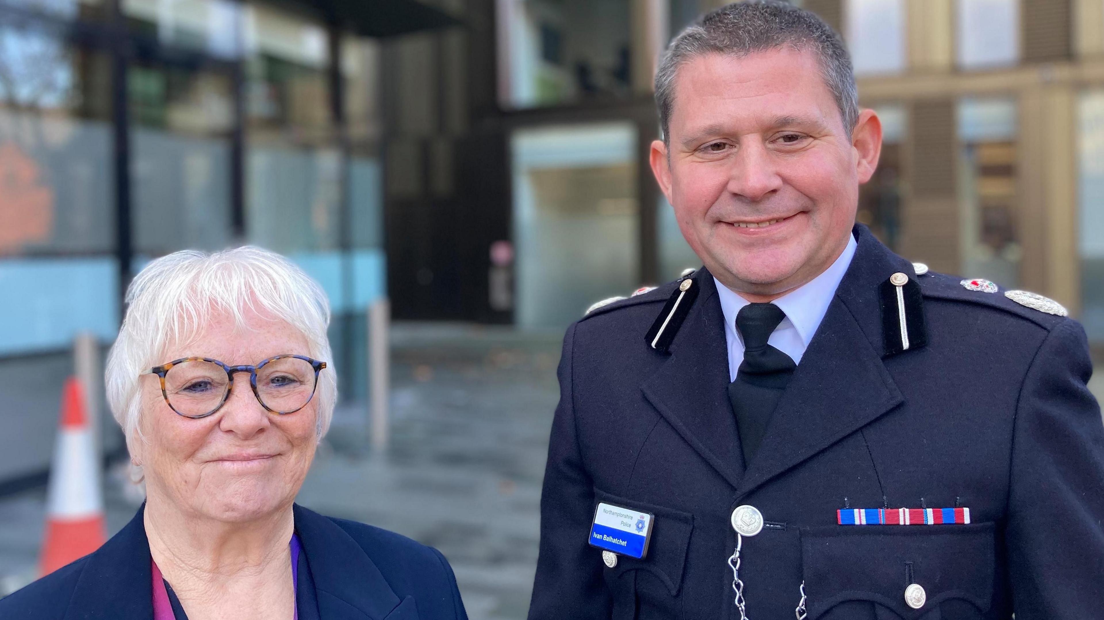 Danielle Stone smiling at camera and wearing a navy blue jacket and glasses standing in front of council offices in Northampton 
Ivan Balhatchet in police uniform 