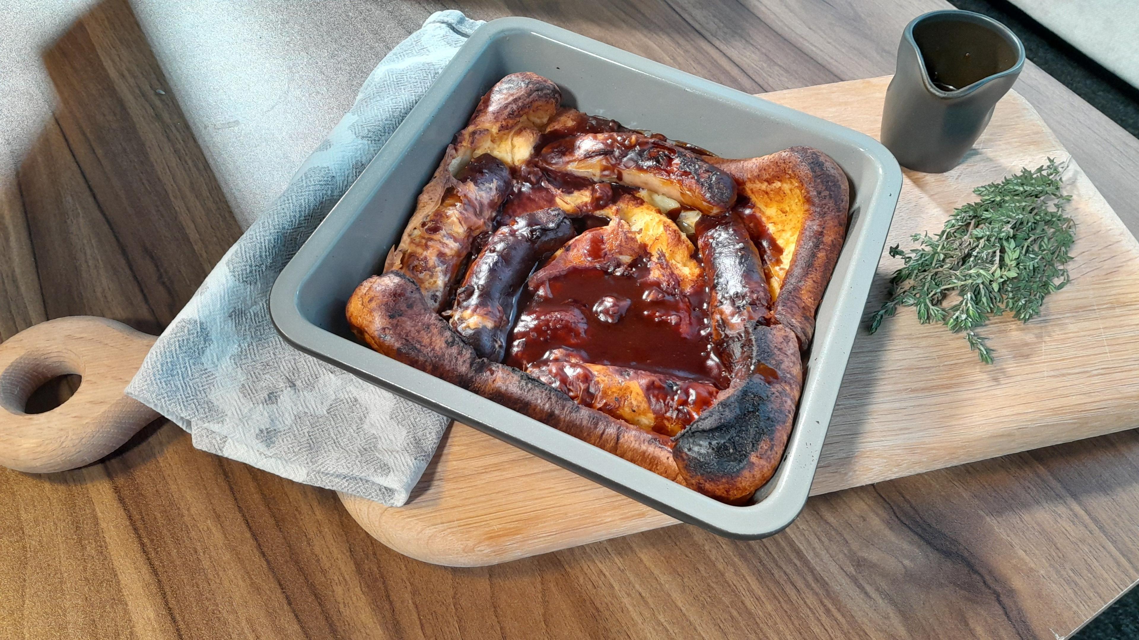 Briony's toad-in-the-hole. A selection of dark brown sausages, set into a puffed up yellow and brown Yorkshire pudding batter.