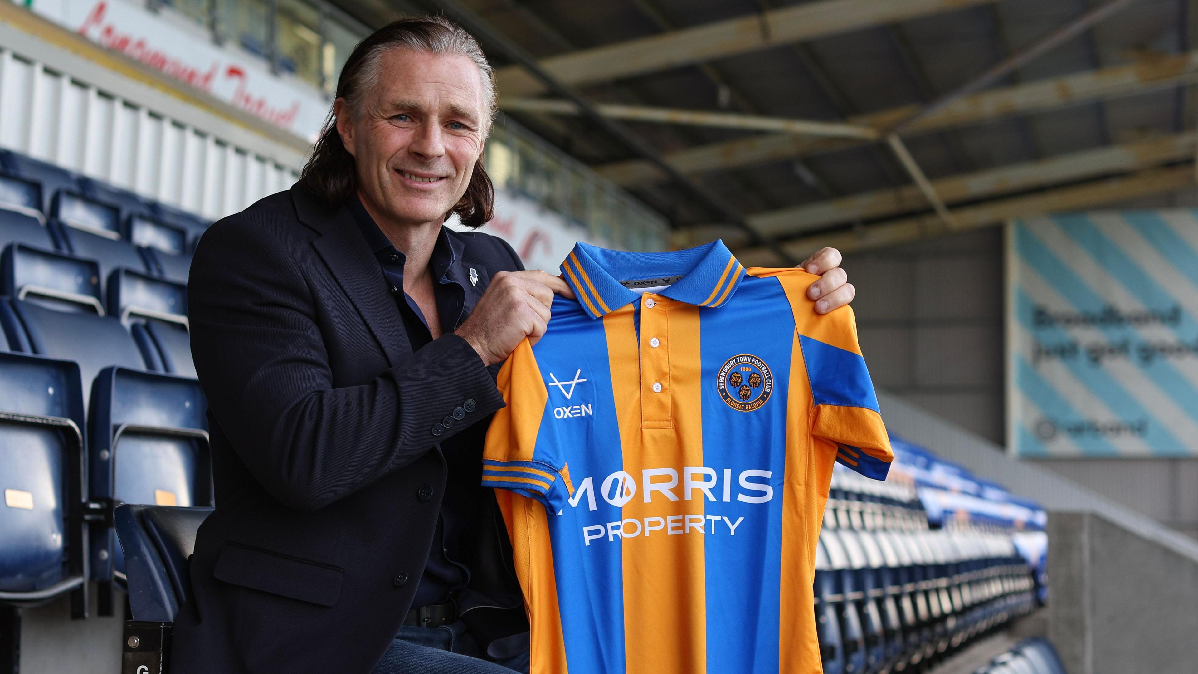 Gareth Ainsworth poses with a Shrewsbury shirt 