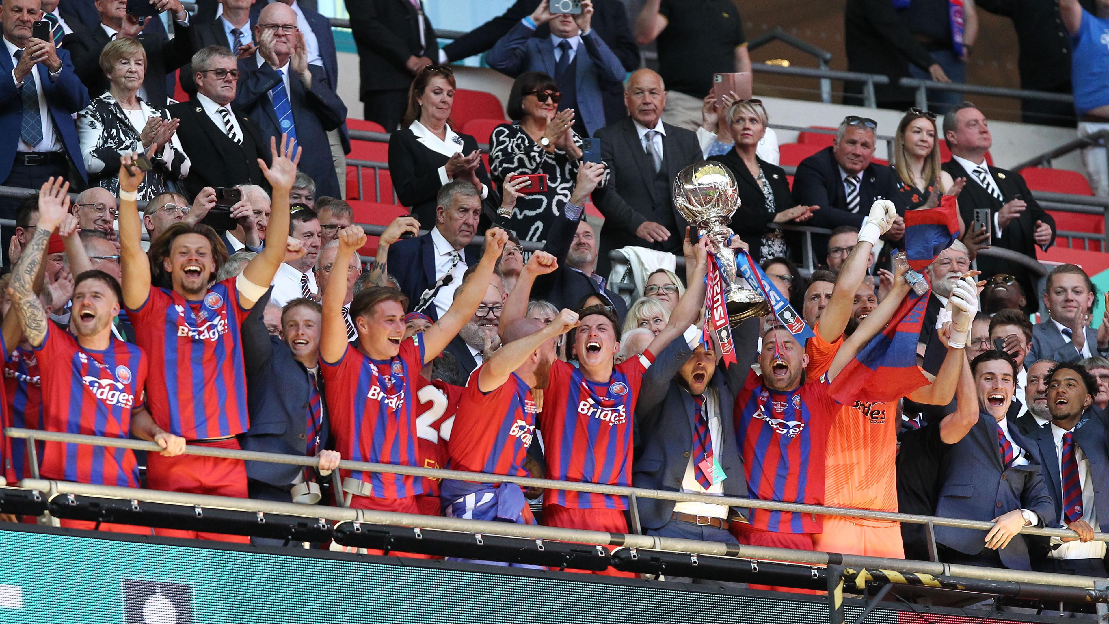 Shots team hold trophy aloft on Wembley balcony