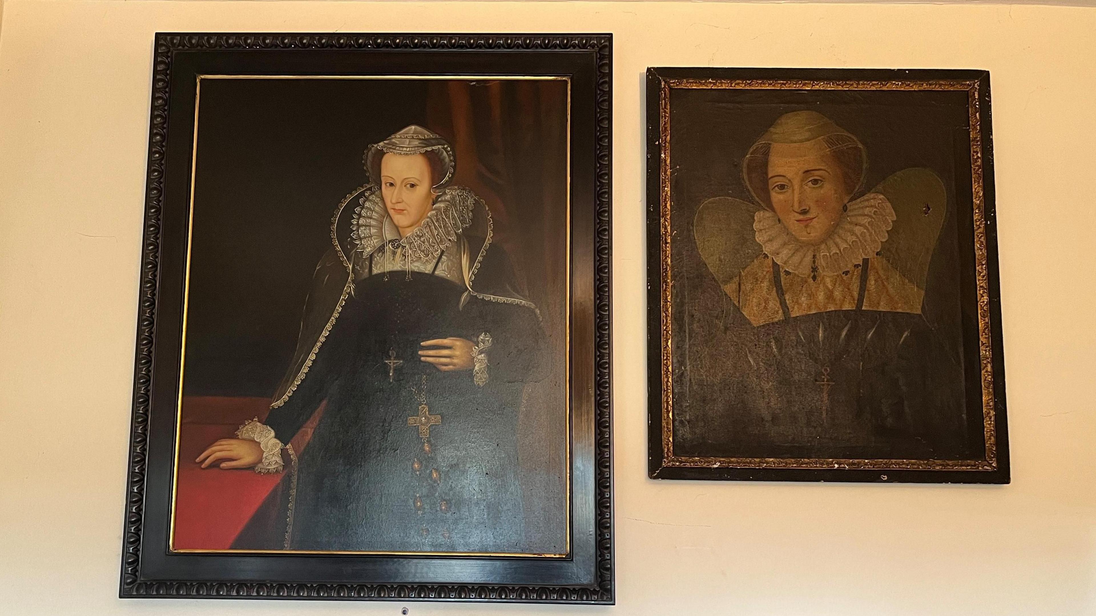 Two portraits of Mary Queen of Scots hanging on a wall. The picture on the left is bigger than the one on the right.