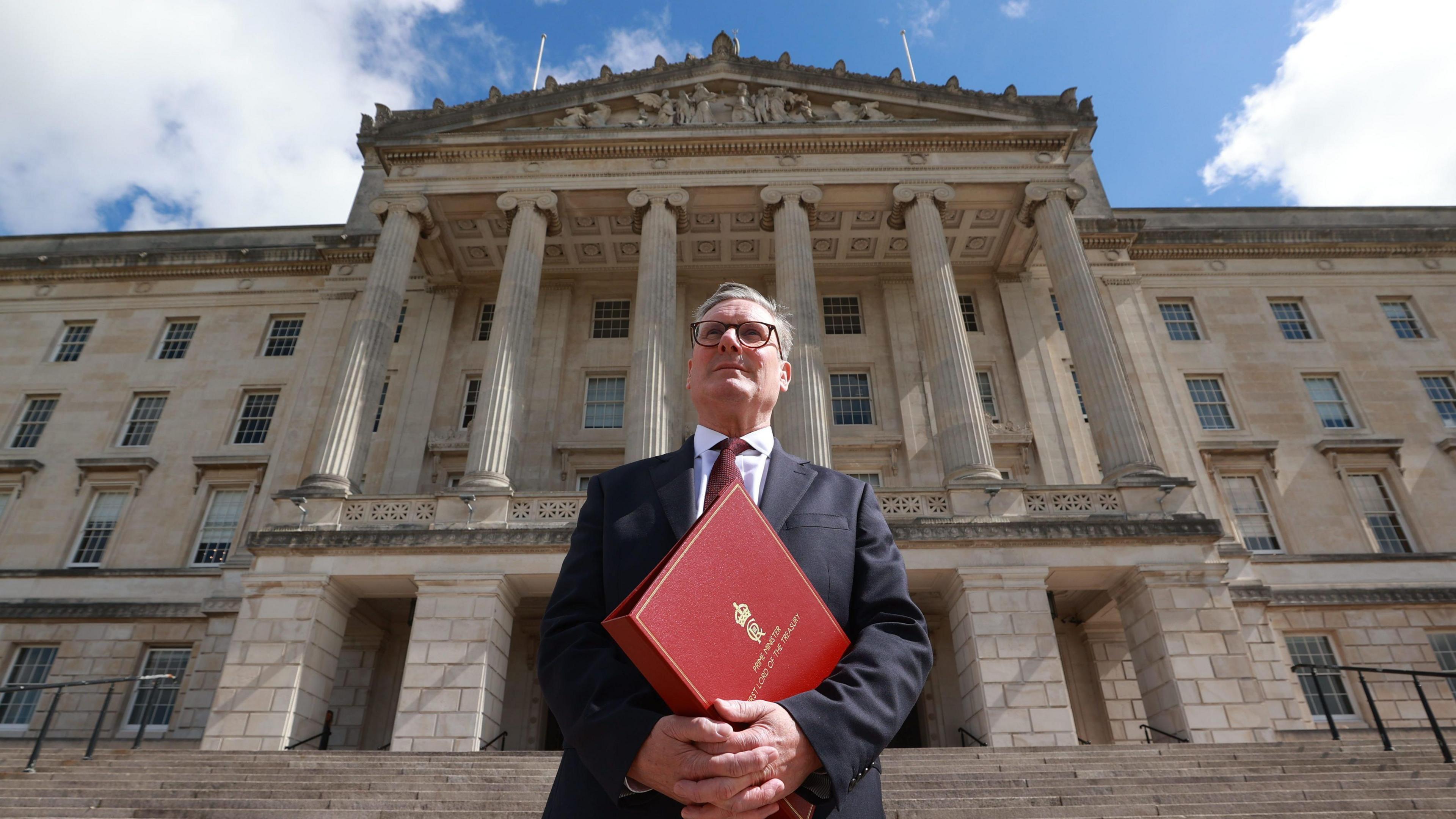 Sir Keir Starmer outside Parliament Buildings in Belfast holding a red binder