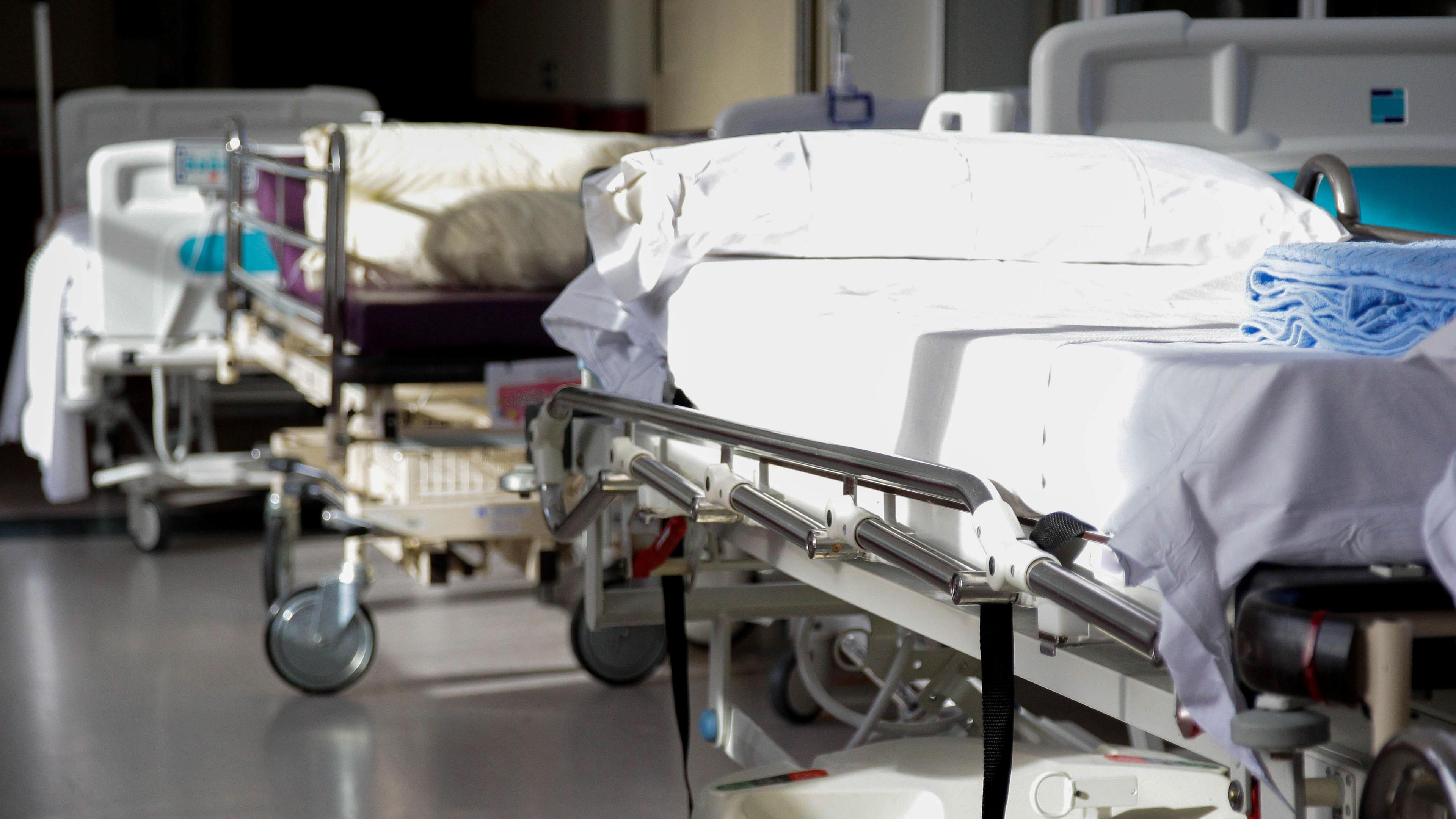 Hospital beds in a hospital ward or corridor. They are empty.