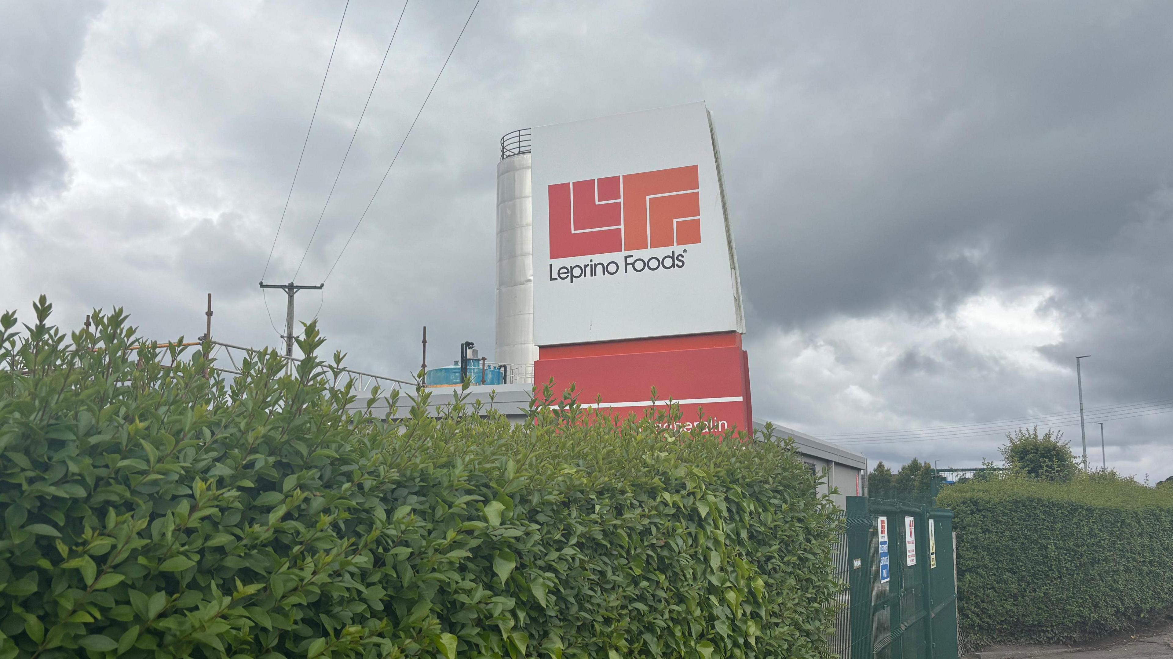A sign saying Leprino Foods. It is a white sign with the words in black. The logo red and orange logo sits above it