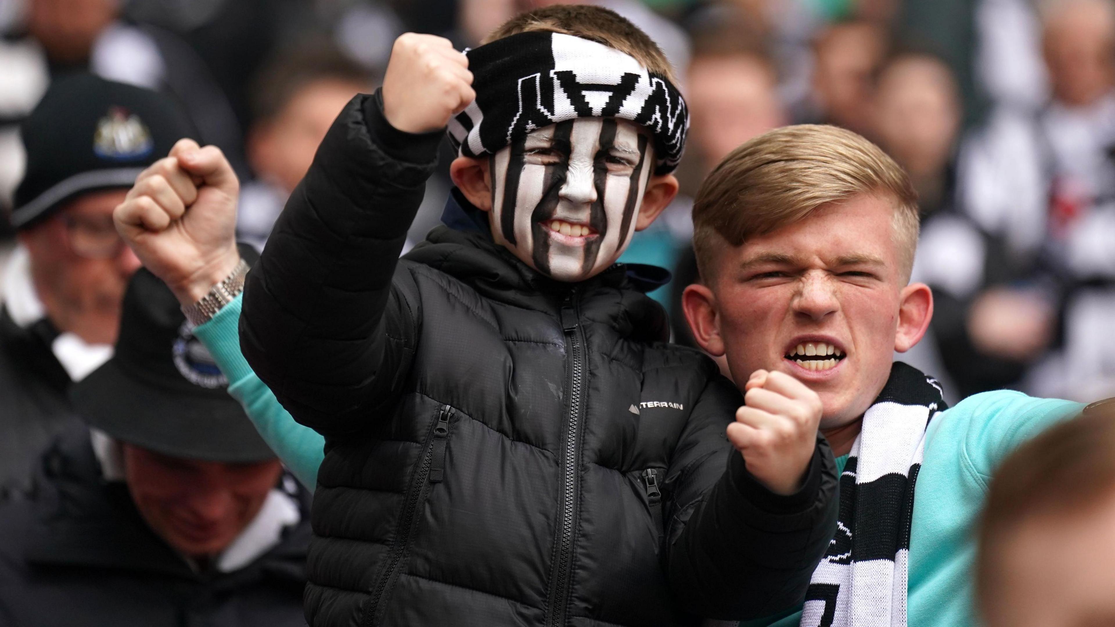 Two young fans celebrate their team winning the Carabao Cup final