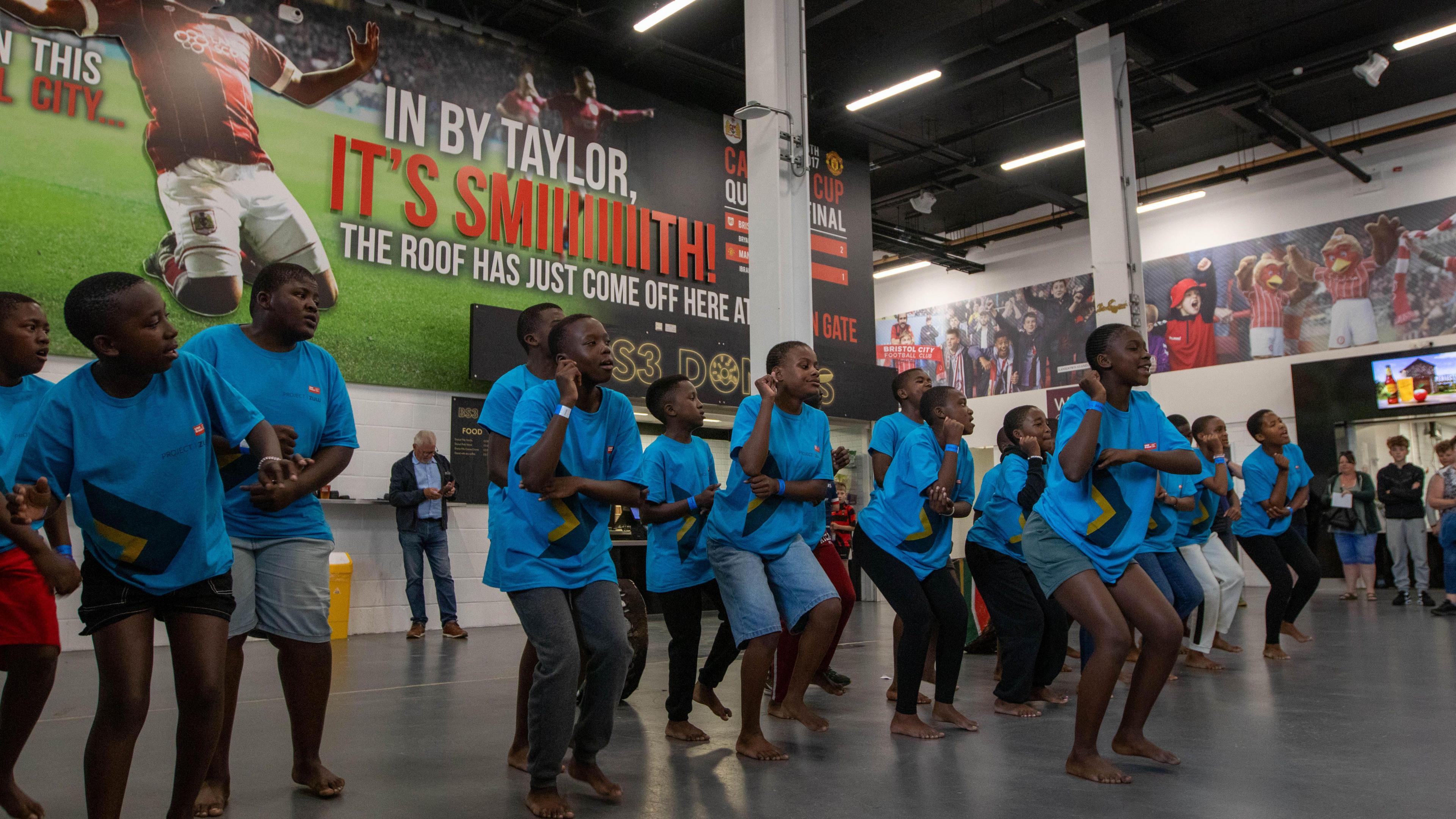 The choir performing inside the stadium at the Bristol Bears game on Saturday. All are huddled together dancing.
