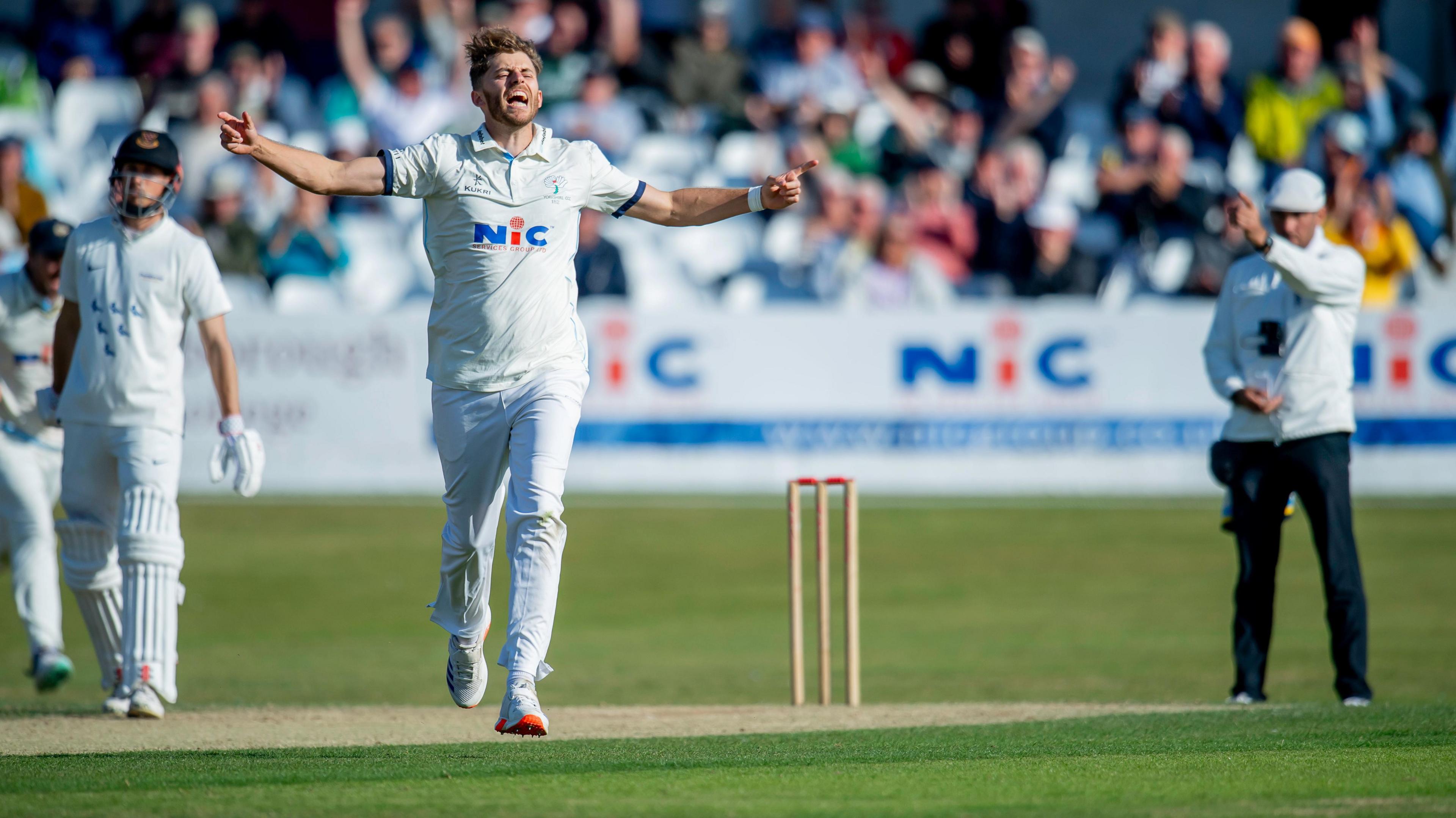 Ben Coad celebrates taking a wicket for Yorkshire.