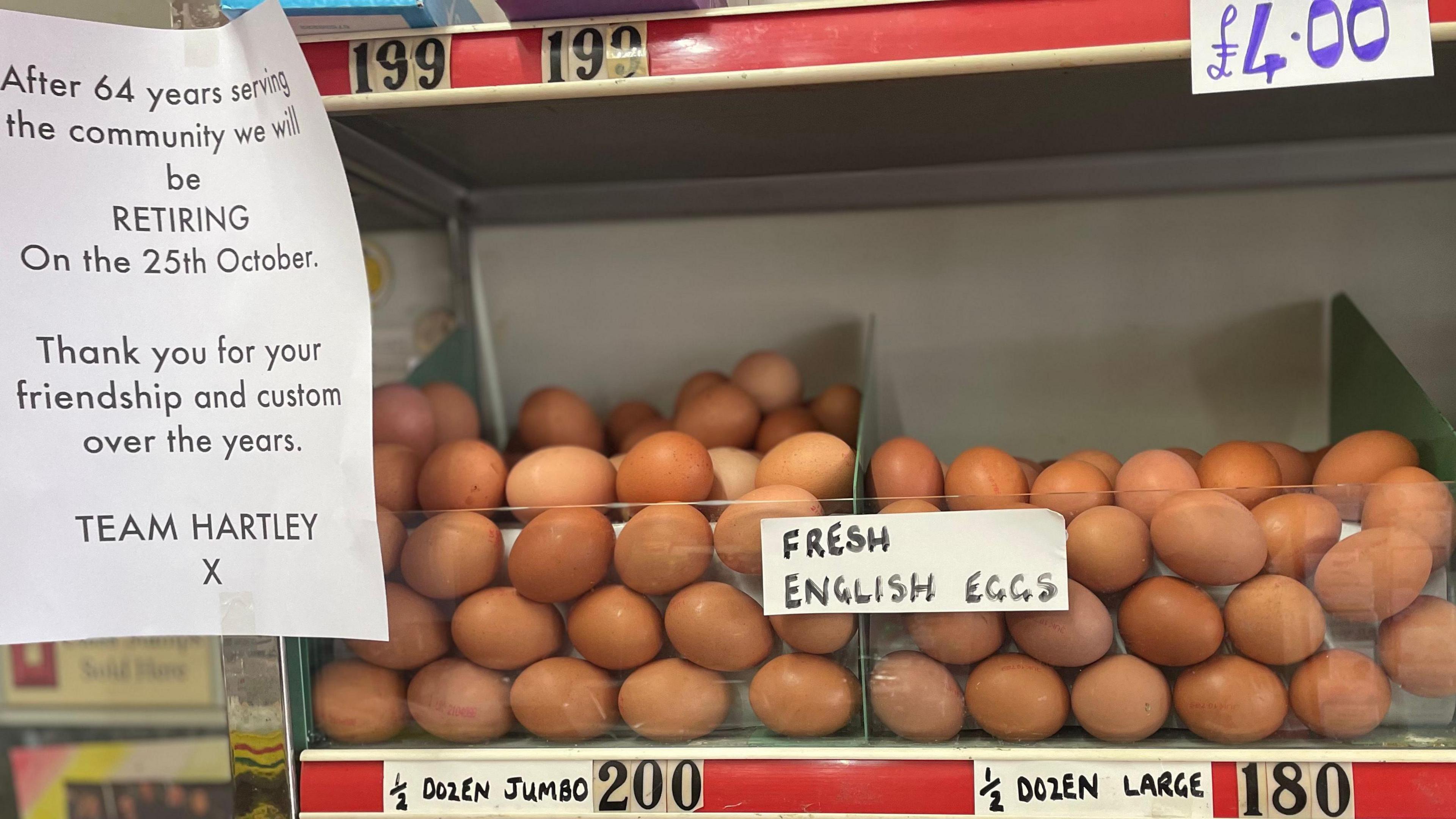 Eggs, loose in a large plastic container, sit on a red and chrome shelf