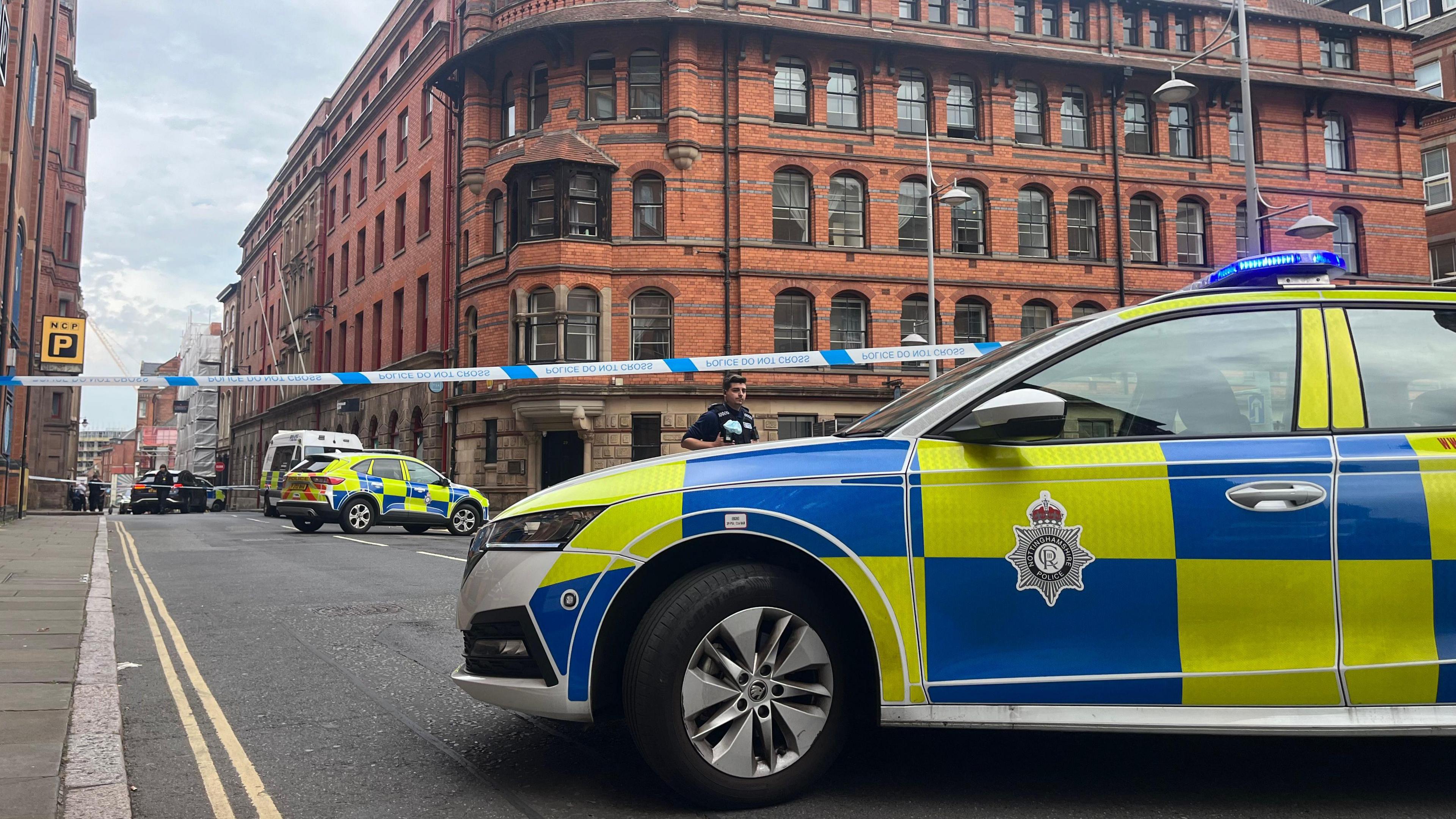 A police car in front of a cordon, with another police car within the cordon in  the background in Barker Gate, in the Lace Market area, Nottingham 