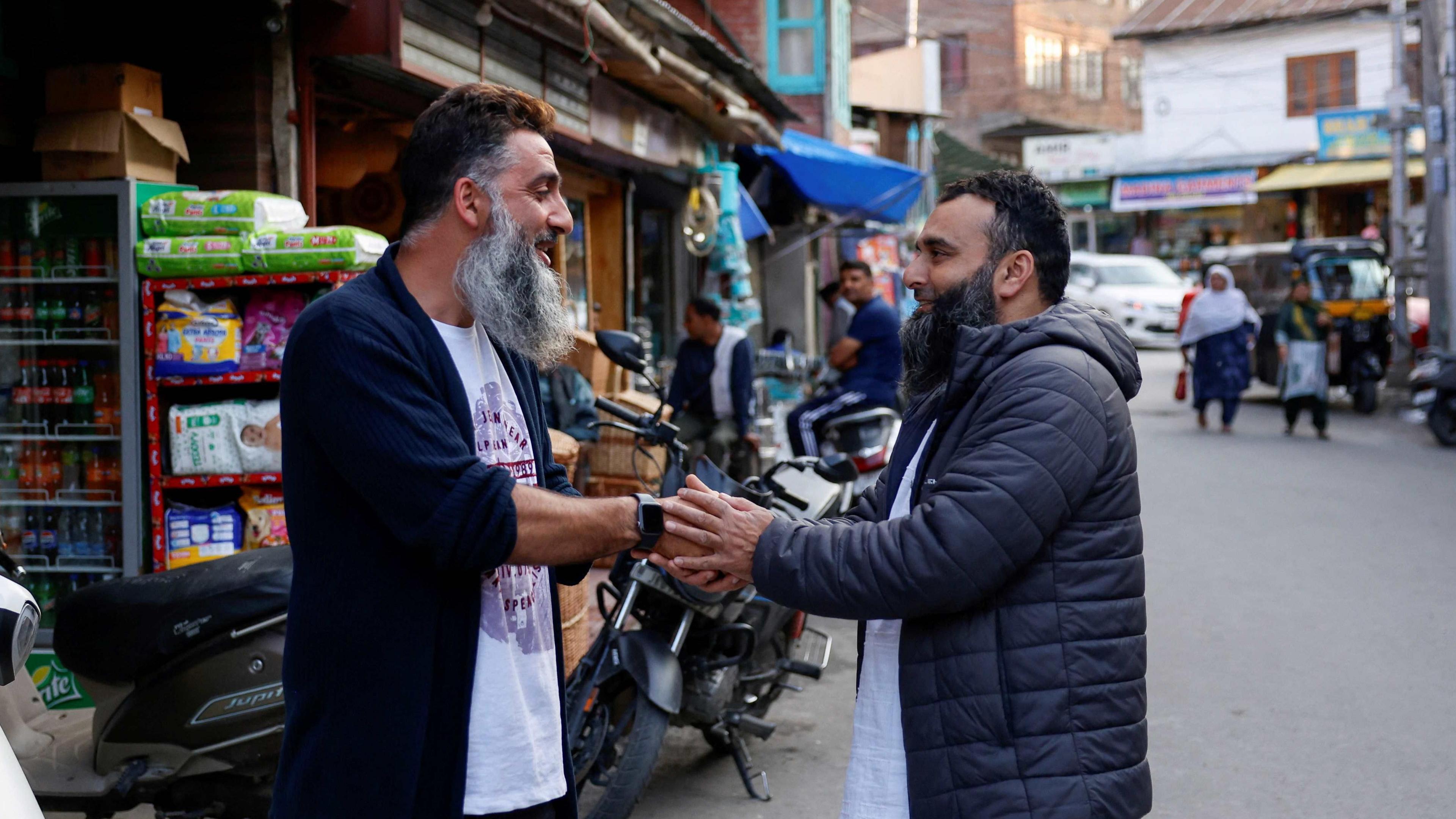 Kashmiri men greet each other after the ceasefire announcement between India and Pakistan, in Srinagar, May 10, 2025.
