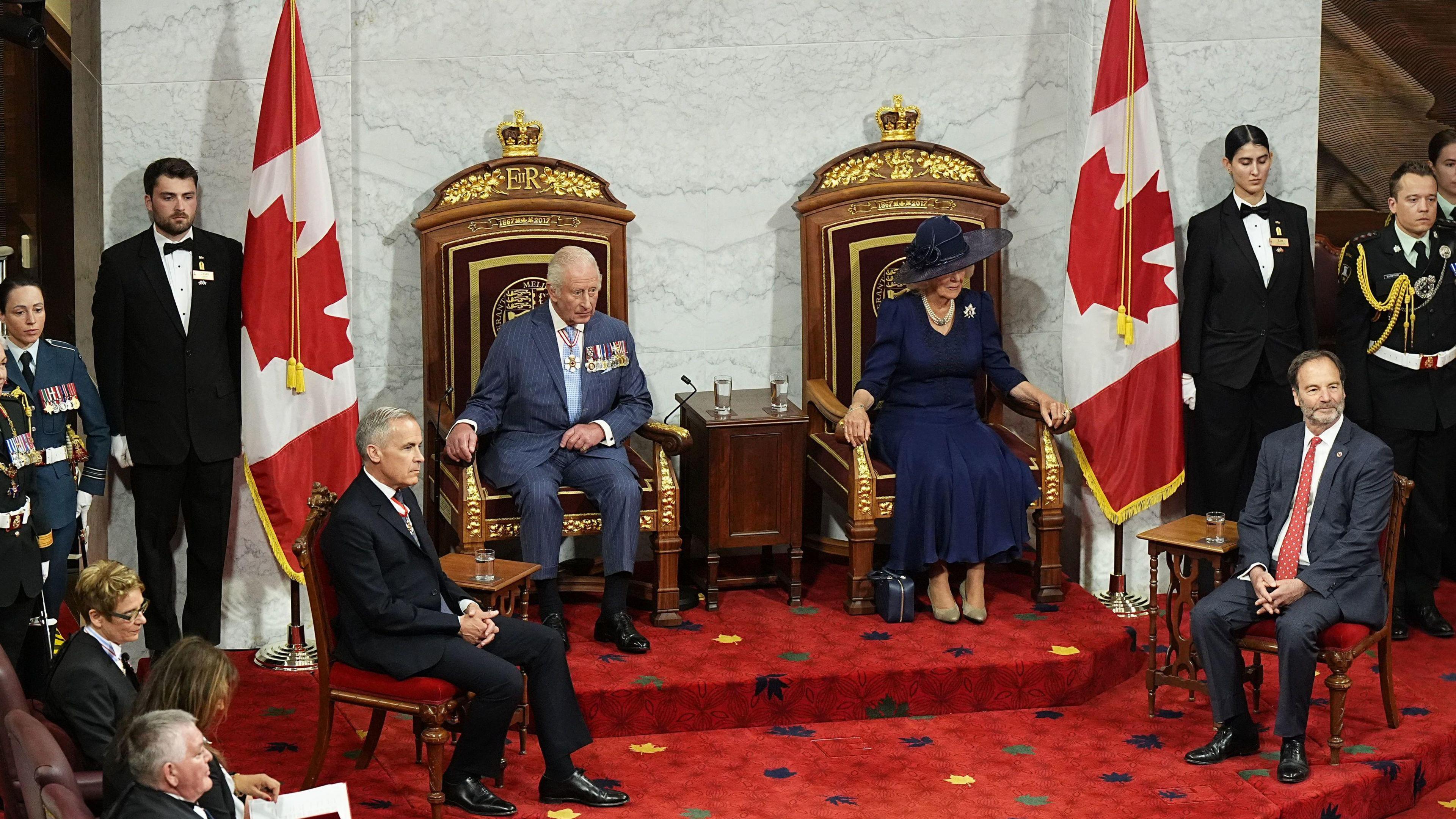 King Charles III and Queen Camilla, sit in thrones, beside Prime Minister of Canada Mark Carney (front of steps, left) and Senator Marc Gold (front right), Government Representative in the Senate, in the Senate Chamber at the Senate of Canada Building, Ottawa, for the State Opening of the Parliament of Canada,