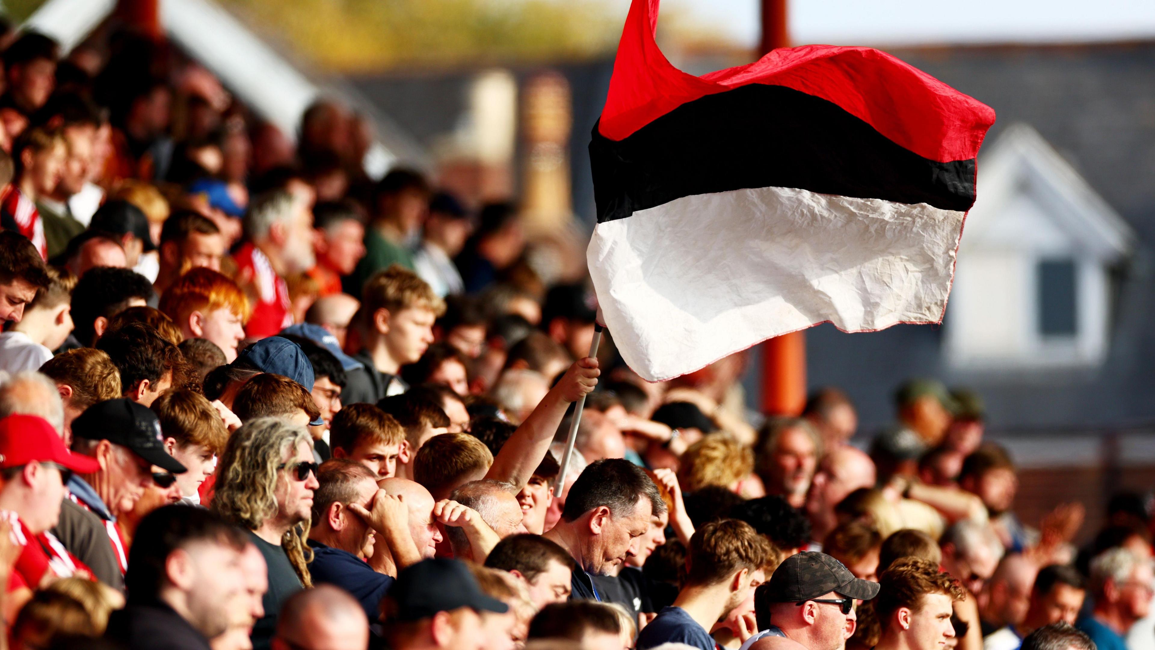 Exeter City fans wave a red, black and white-striped flag