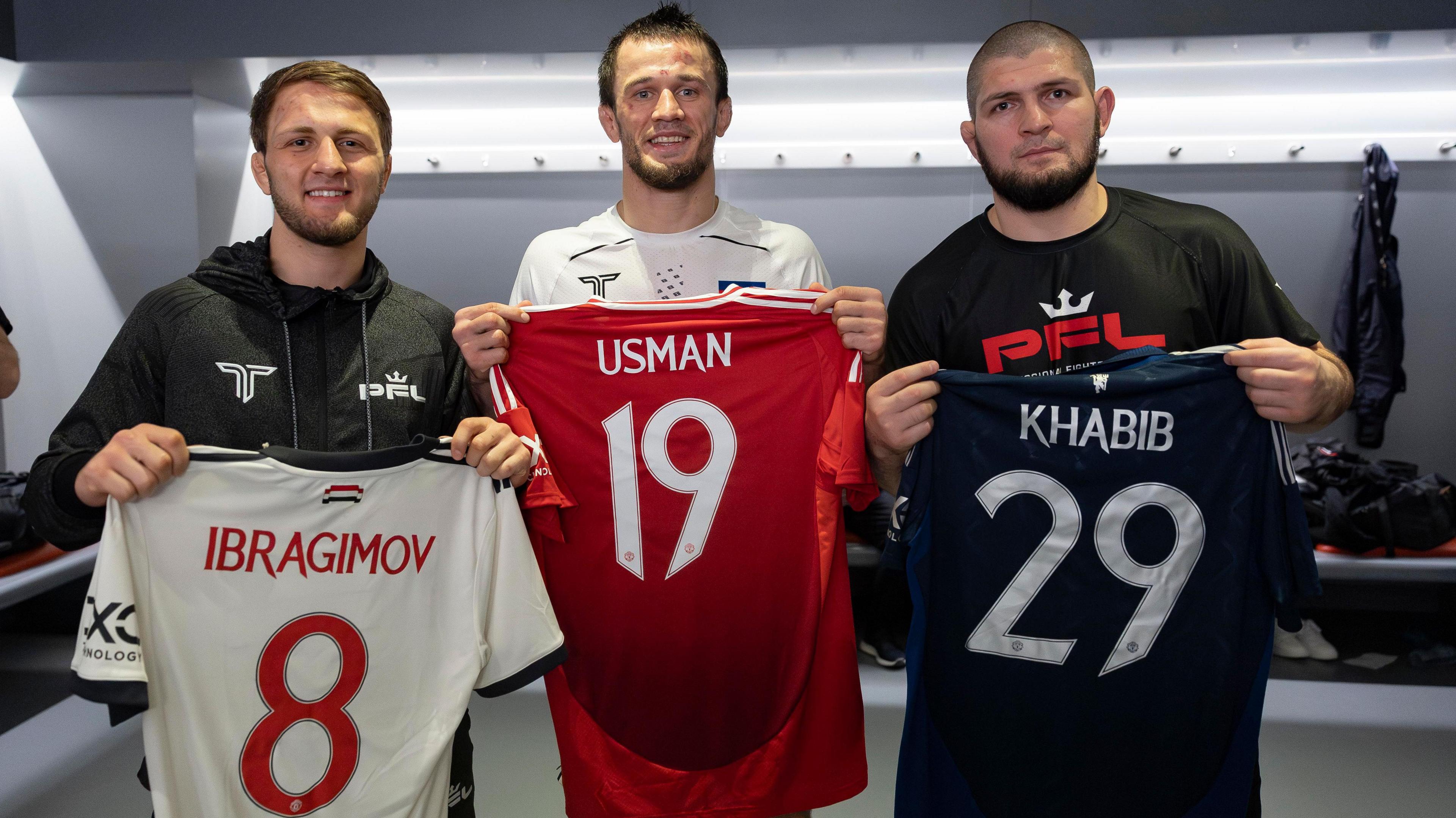 Ibragim Ibragimov poses with Usman Nurmagomedov and Khabib Nurmagomdov while holding up Manchester United shirts with their names on the back