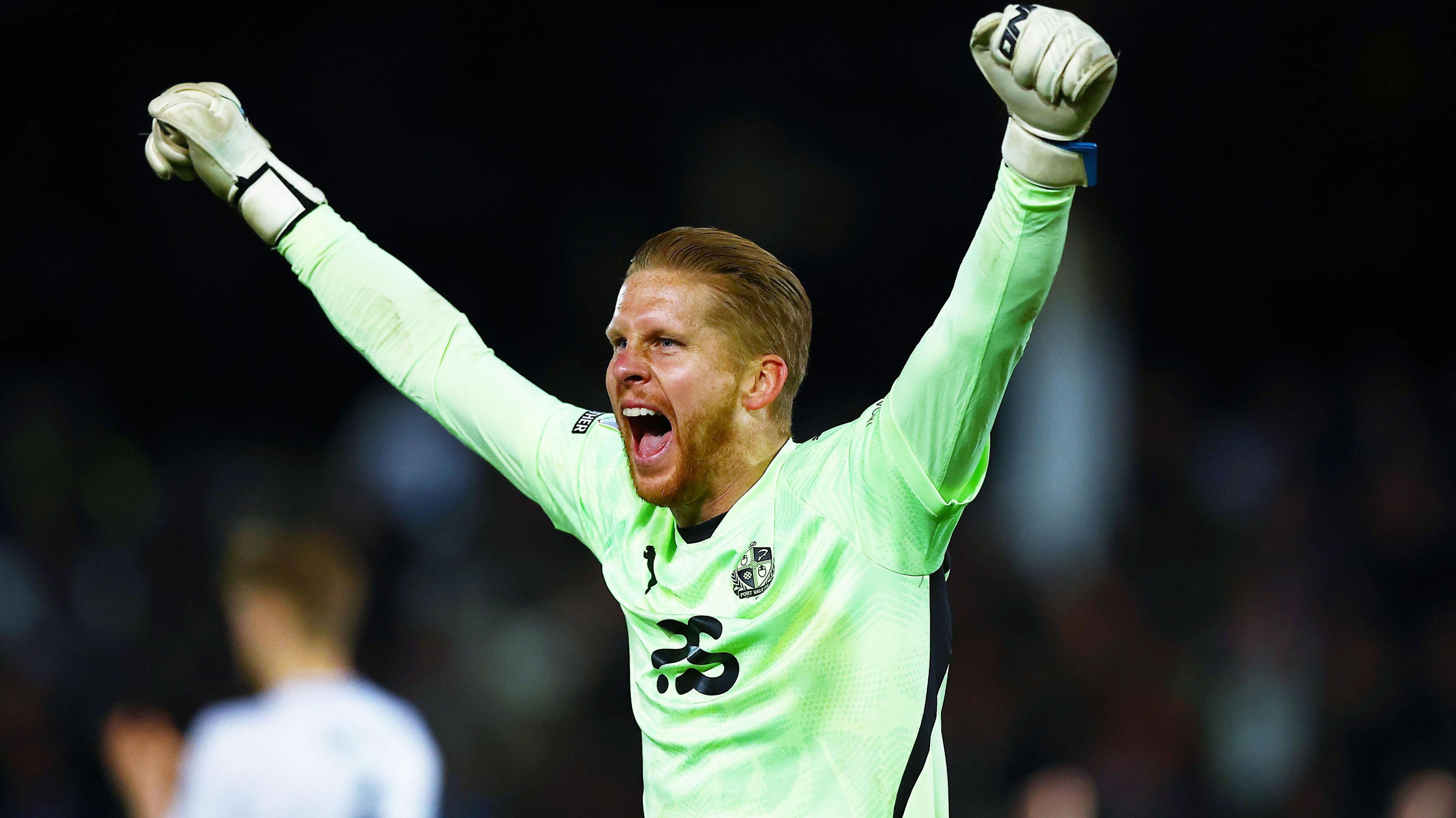 Port Vale goalkeeper Ben Amos throws his arms in the air in celebration and shouts for joy after a win