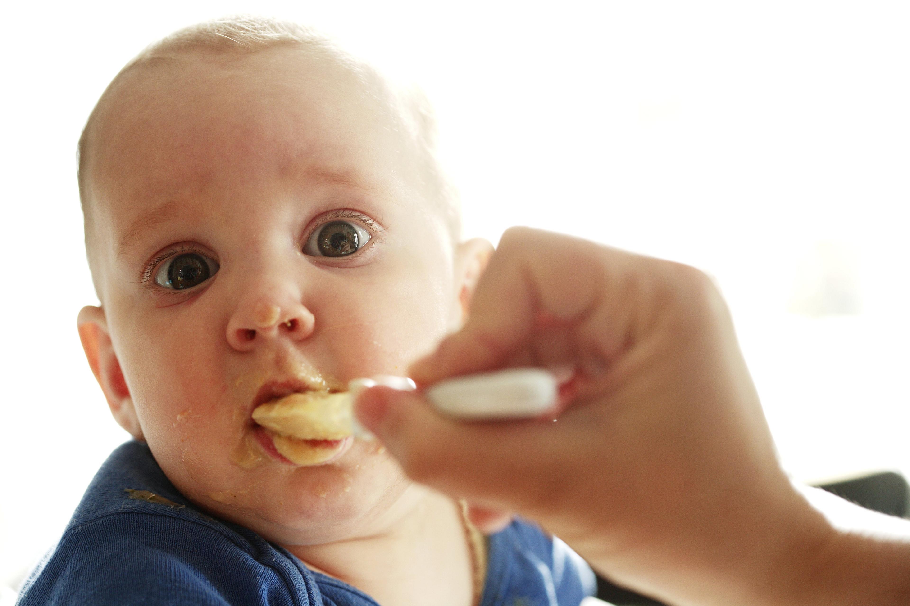 A baby eating baby food