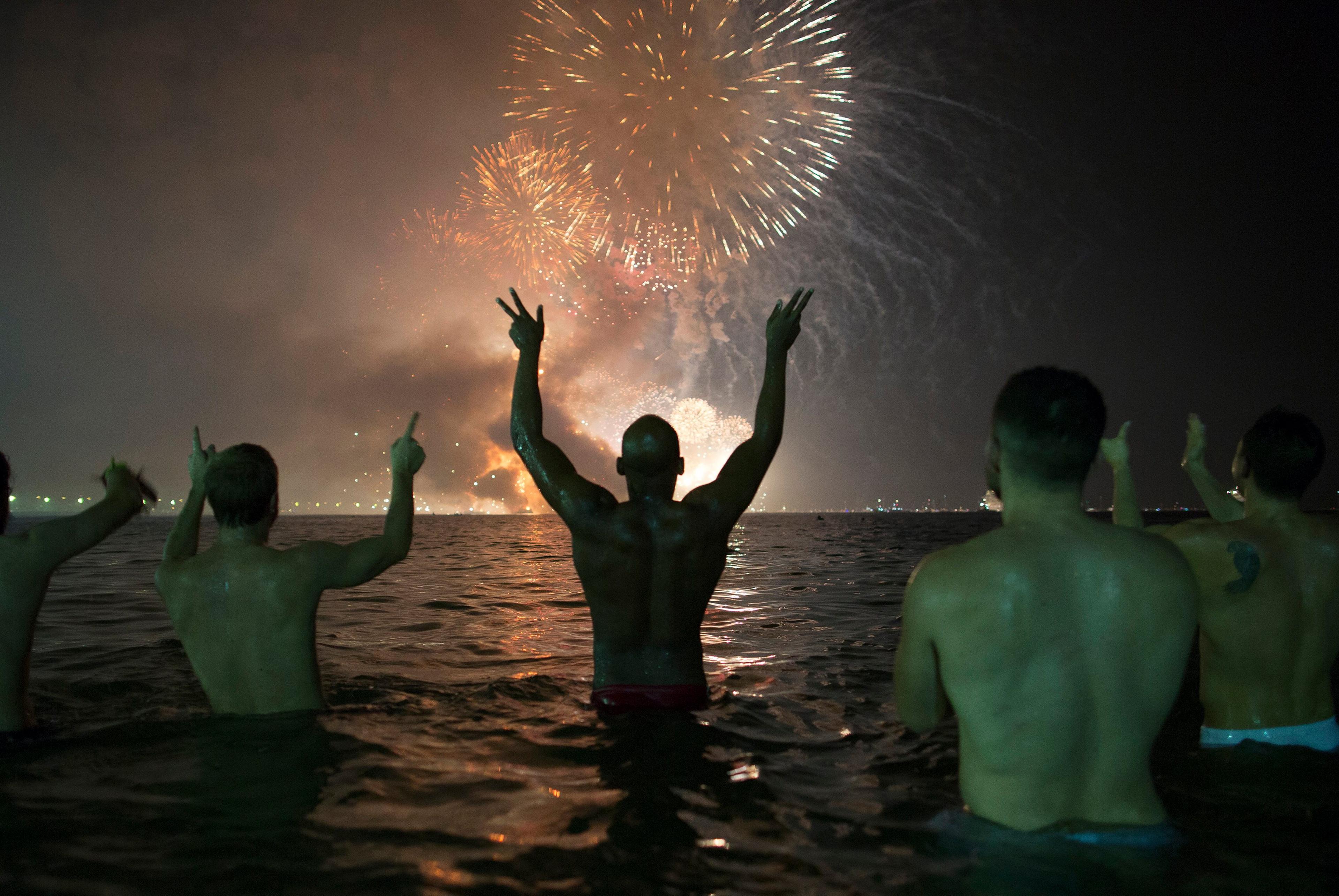 People watch the fireworks exploding over Copacabana beach during the New Year's Eve celebrations in Rio de Janeiro, Brazil